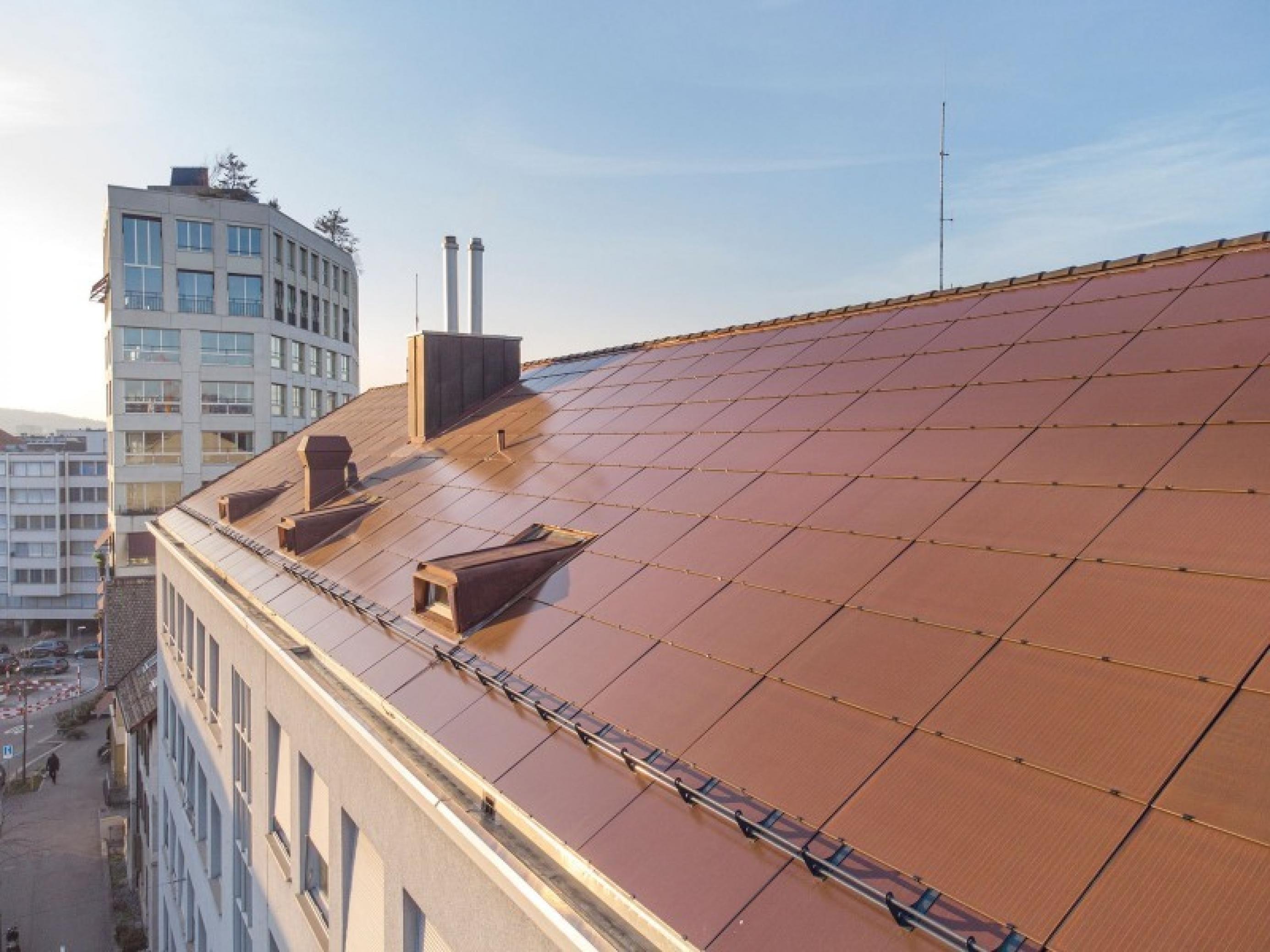 Eine Solardach mit orangefarbenen Solardachmodulen.