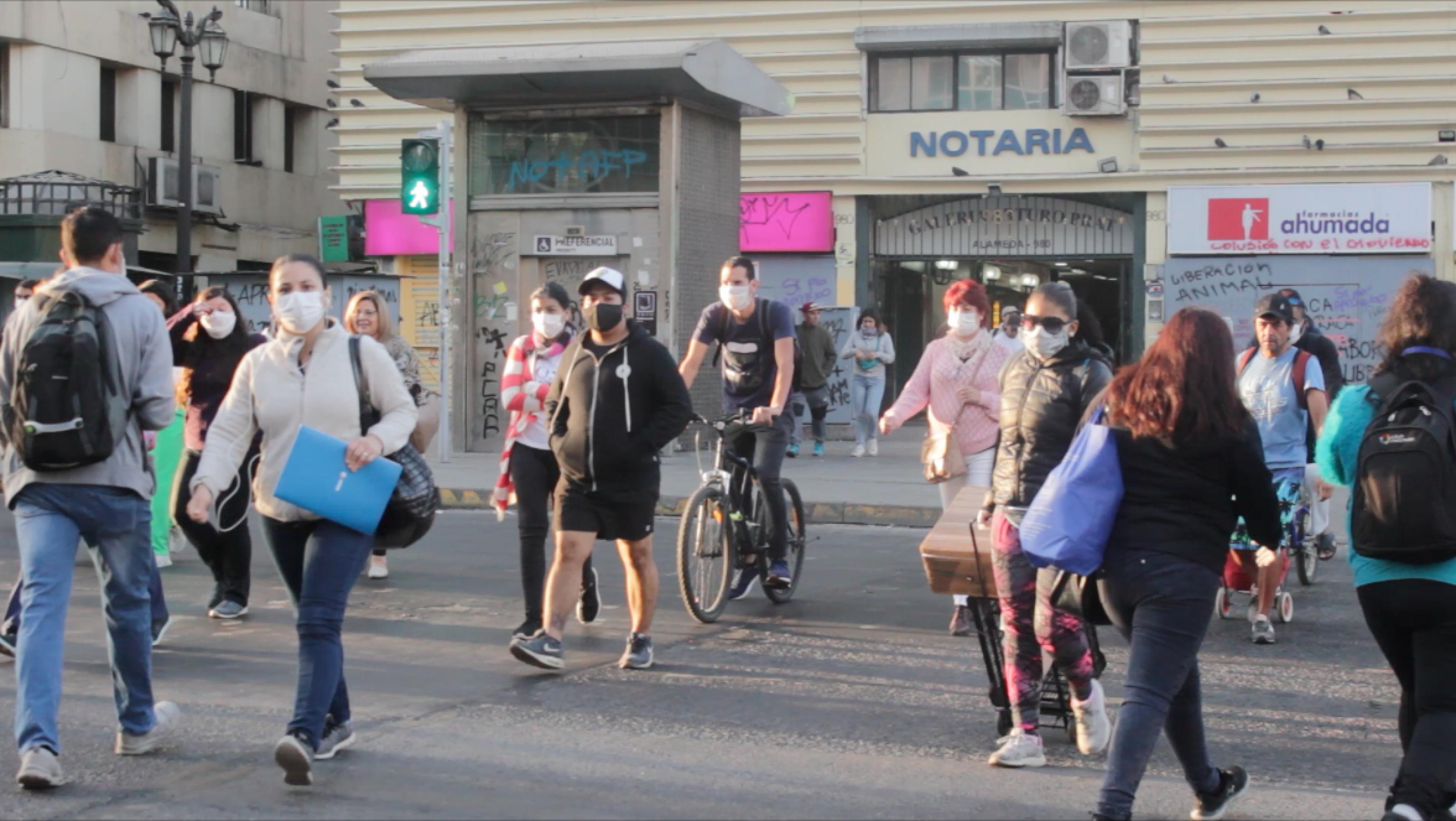 Menschen mit Mundschutzmasken auf einer Straße in Santiago.