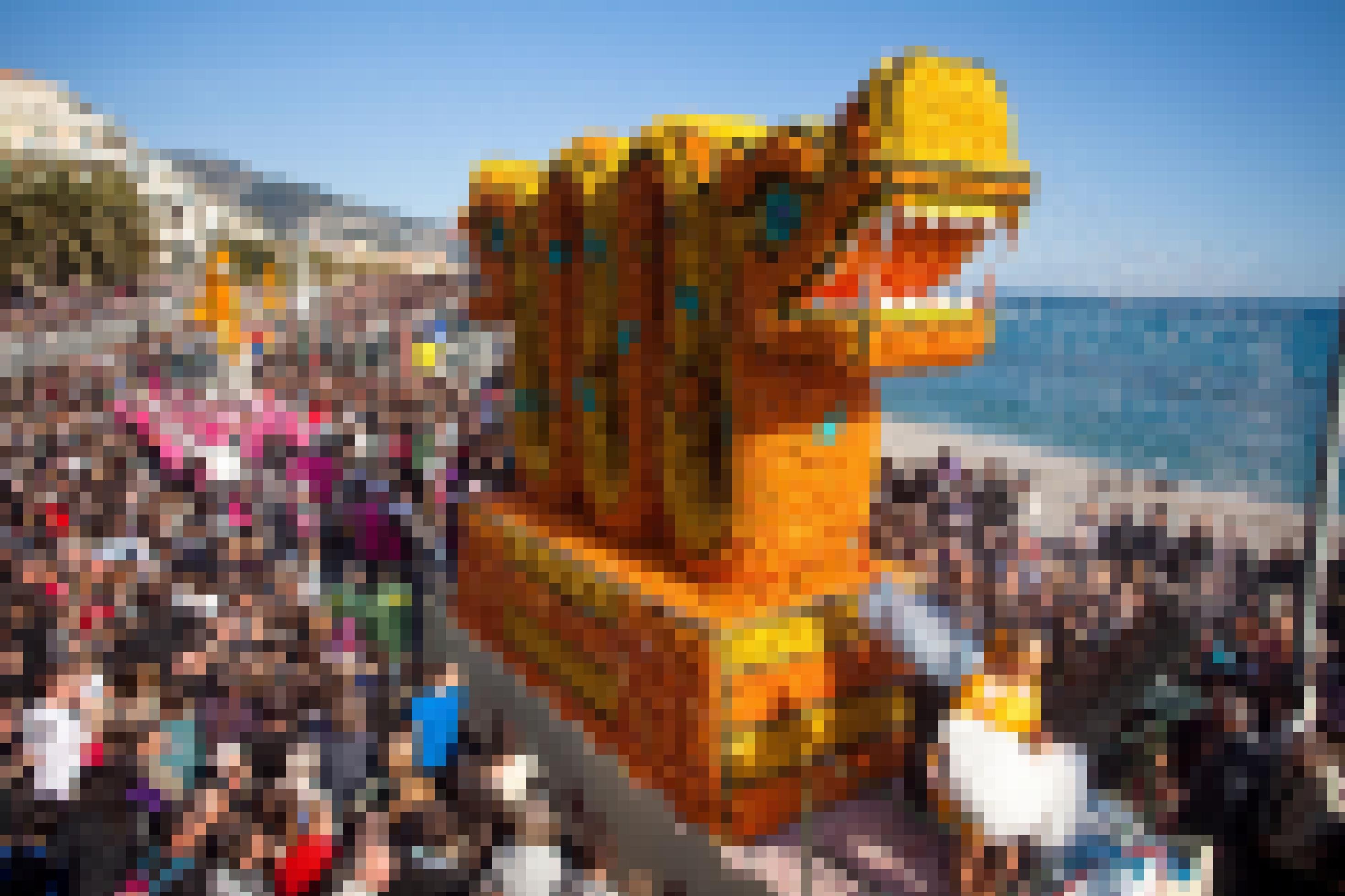 Mit Zitronen und Orangen geschmückter Drache bewegt sich an der Küste bei Menton im Karnevalszug