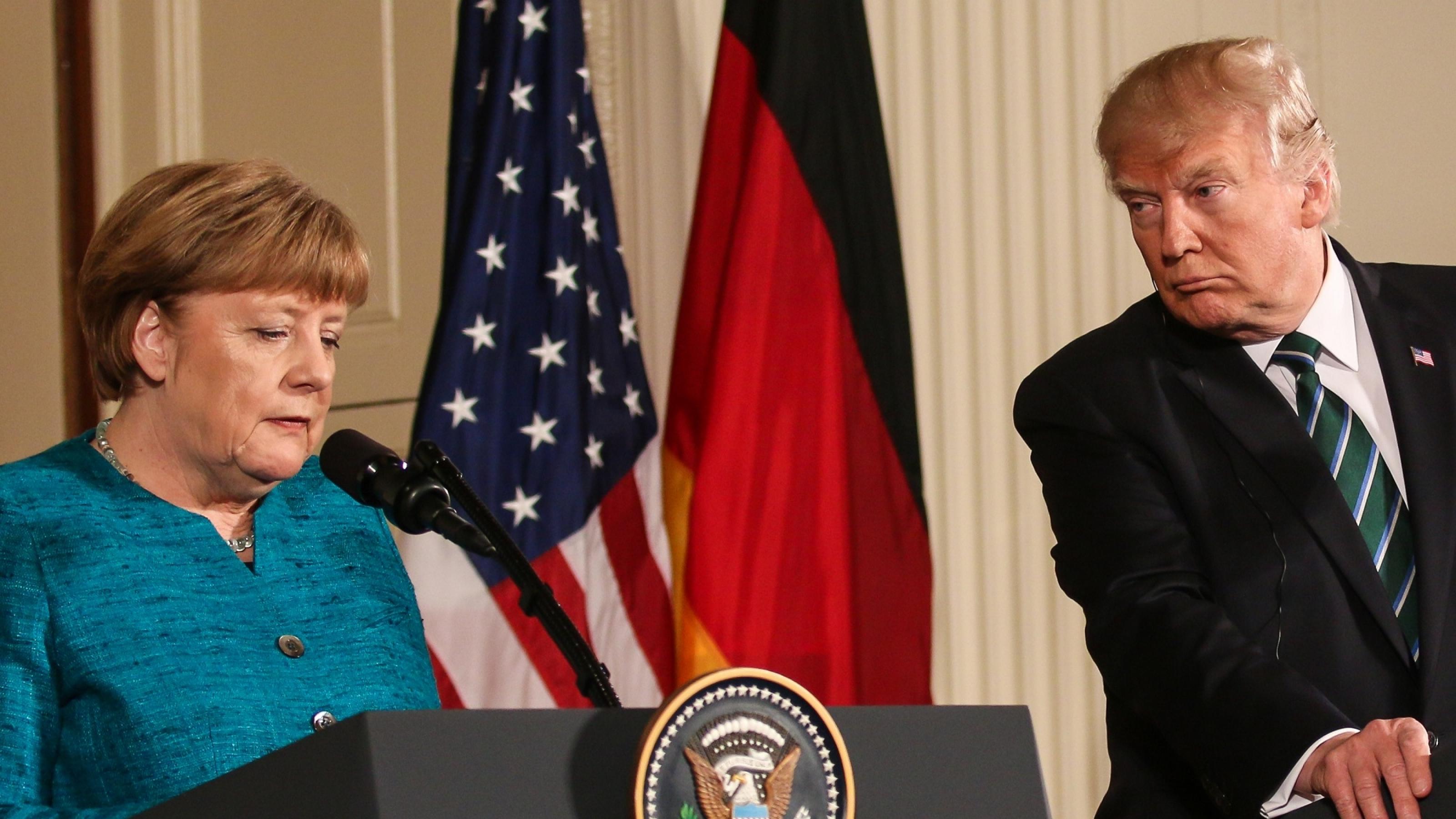Angela Merkel und Donald Trump stehen nebeneinander bei einer Pressekonferenz. Trump schaut Merkel skeptisch an.