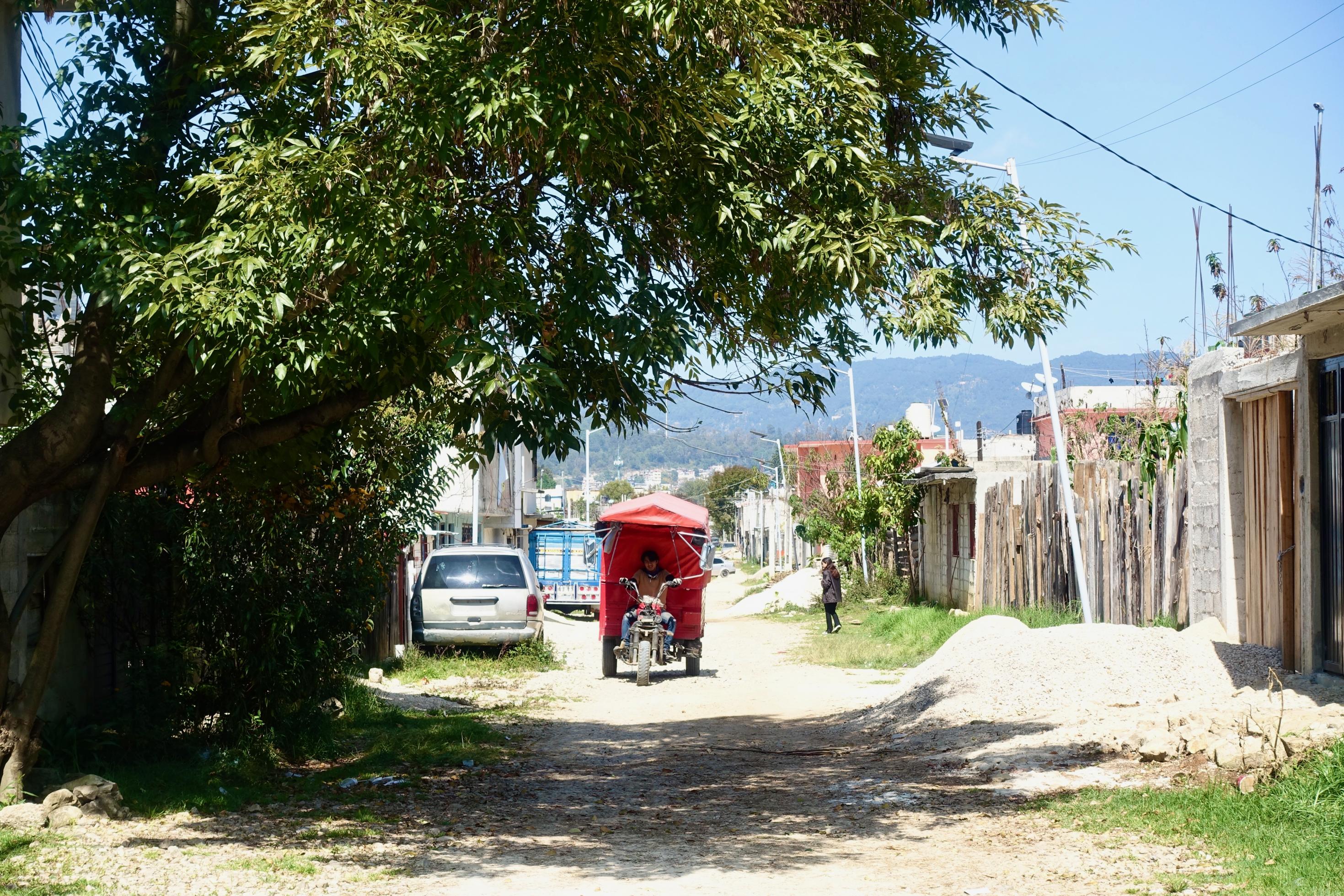 Auf einer nicht befestigten Straße im mexikanischen San Cristobal de las Casas fährt ein Motorradtaxi