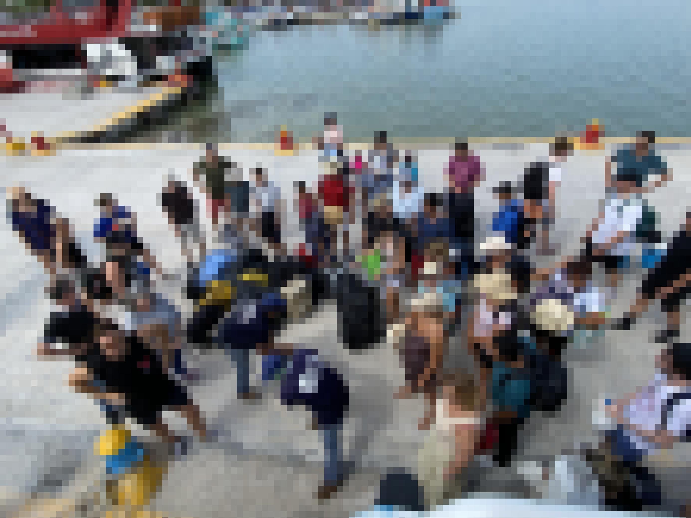 Touristen am Pier, während sie auf ihre Koffer warten, die von der Fähre geladen werden.