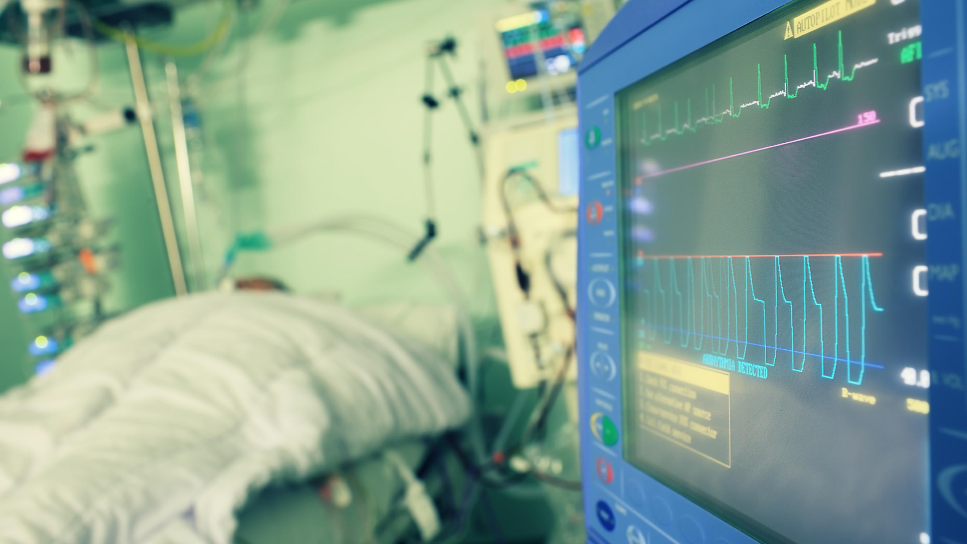 Das Symbolfoto stellt einen Patienten auf der Intensivstation eines Krankenhauses dar. Ein Monitor stellt Informationen über seinen Gesundheitszustand dar.