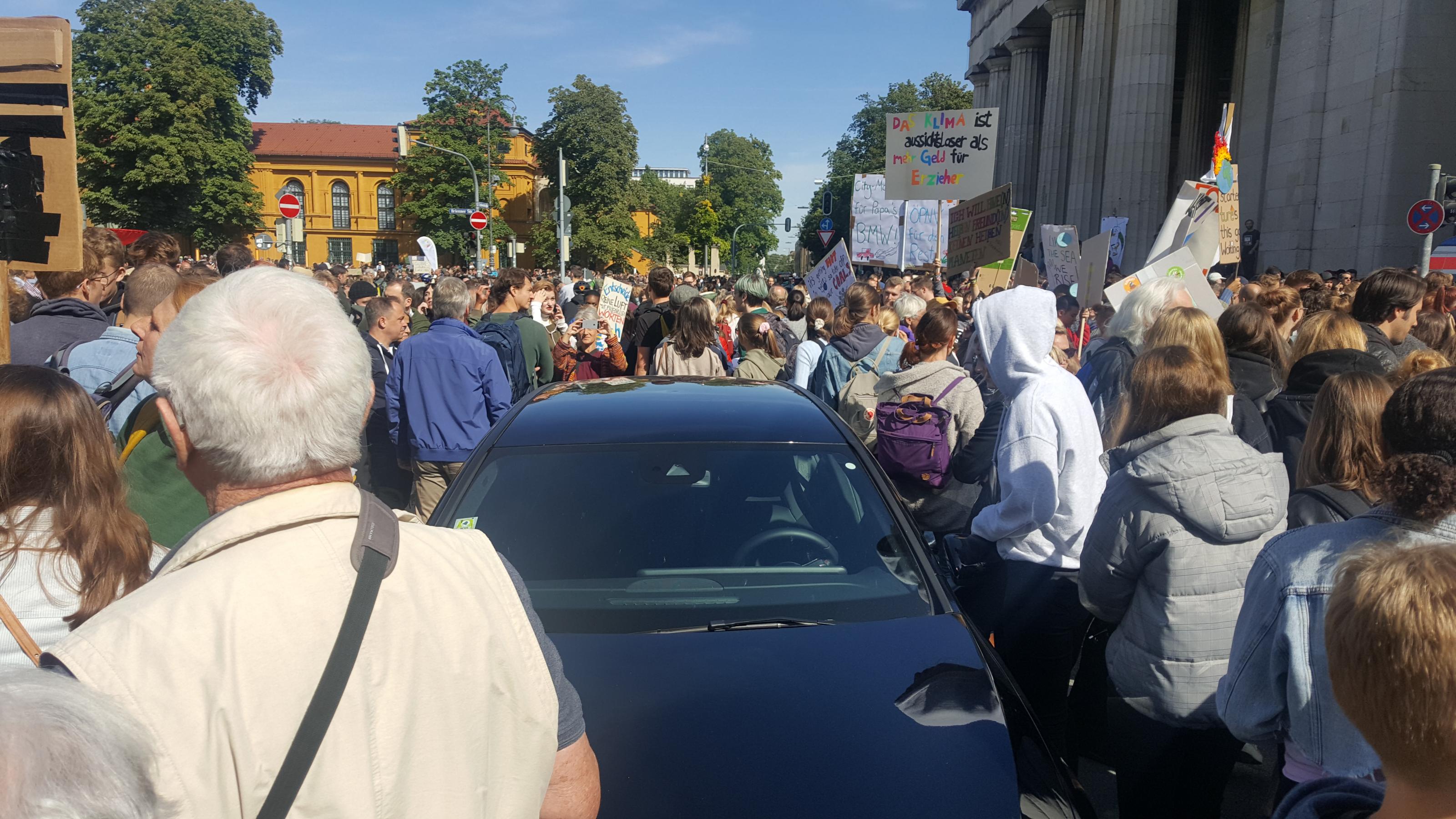 Ein verlassenes Auto in der Münchner Innenstadt, das im Demonstrationszug stecken blieb.