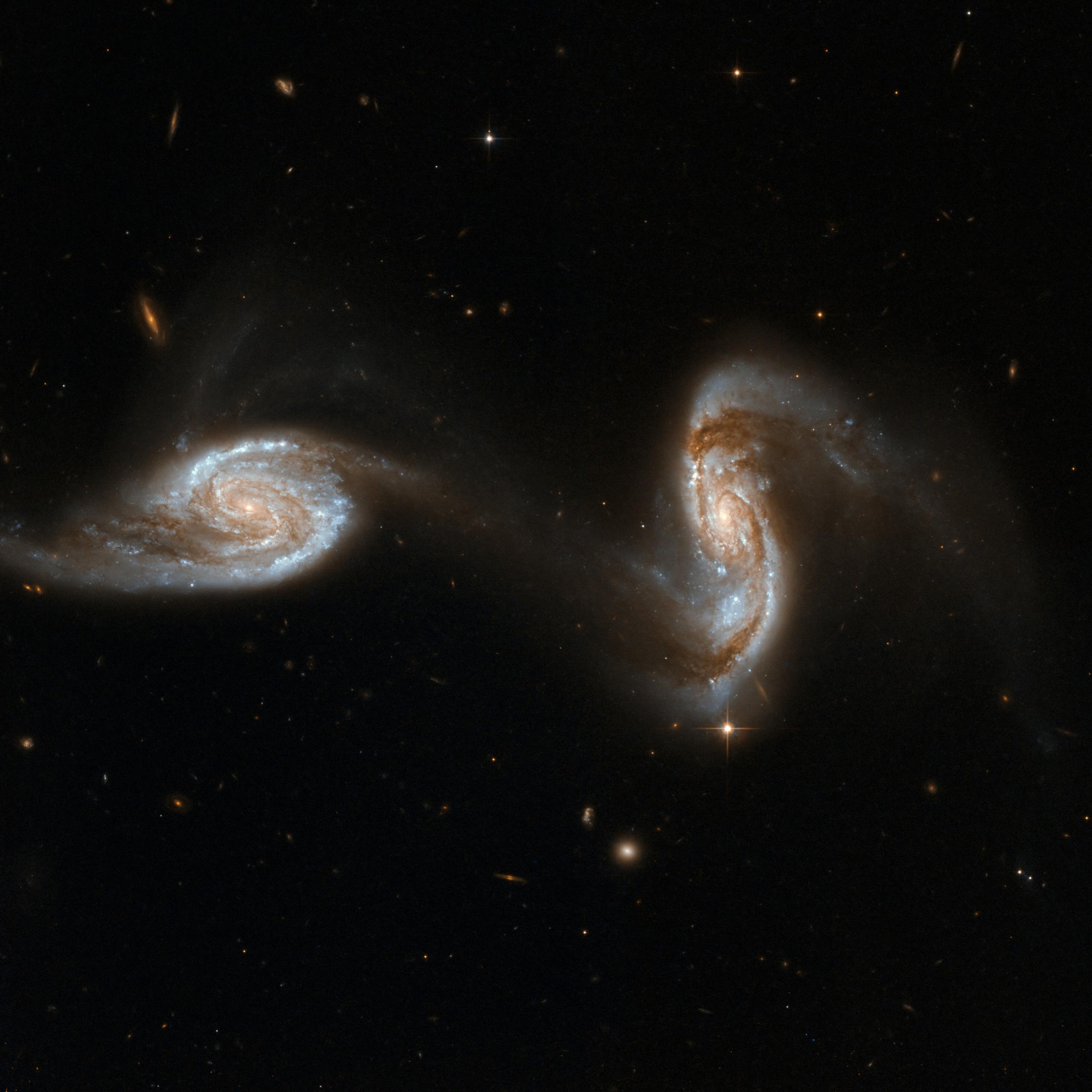 Zwei Galaxien sind sich sehr nahe gekommen, so dass ein Arm der einen bereits in die zweite Galaxie übergeht.