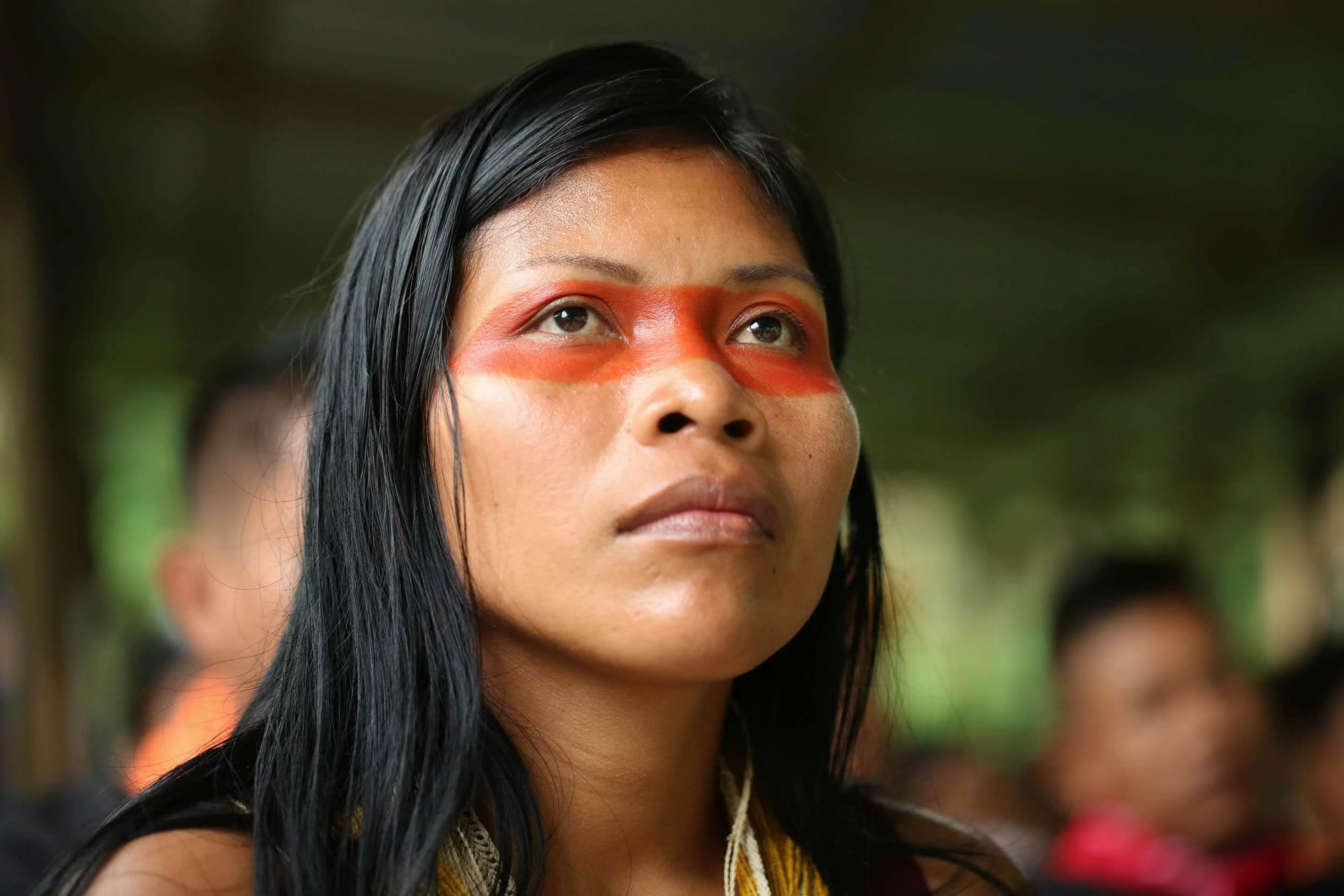 Das Gesicht der indigenen Umweltschützerin Nemonte Nenquimo ist um die Augen herum mit der roten Farbe der Achiote-Pflanze bemalt.