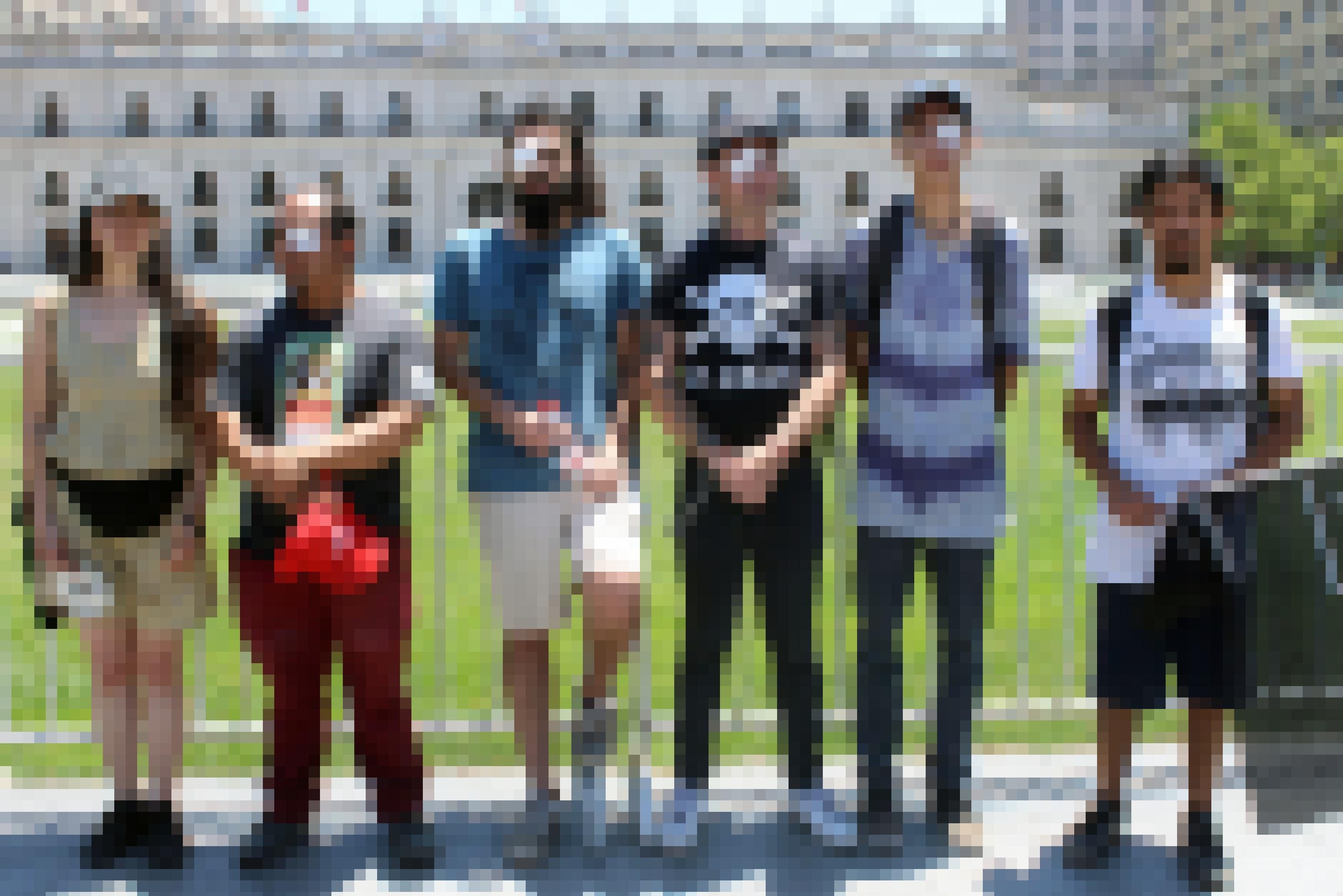 eine Gruppe Männer steht vor einem Zaun [AI]