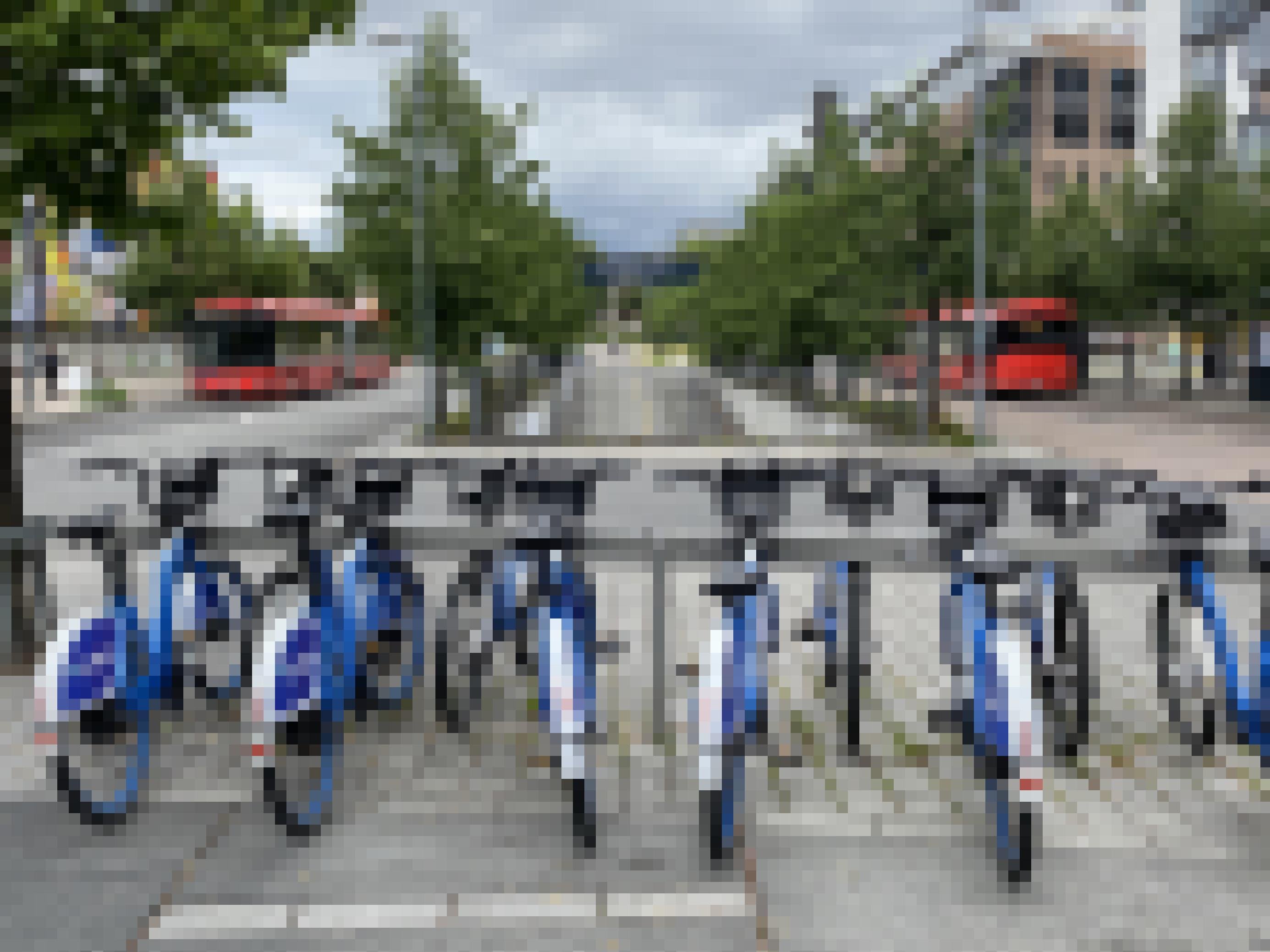 Eine Station mit Leihrädern steht an einer Busstation.