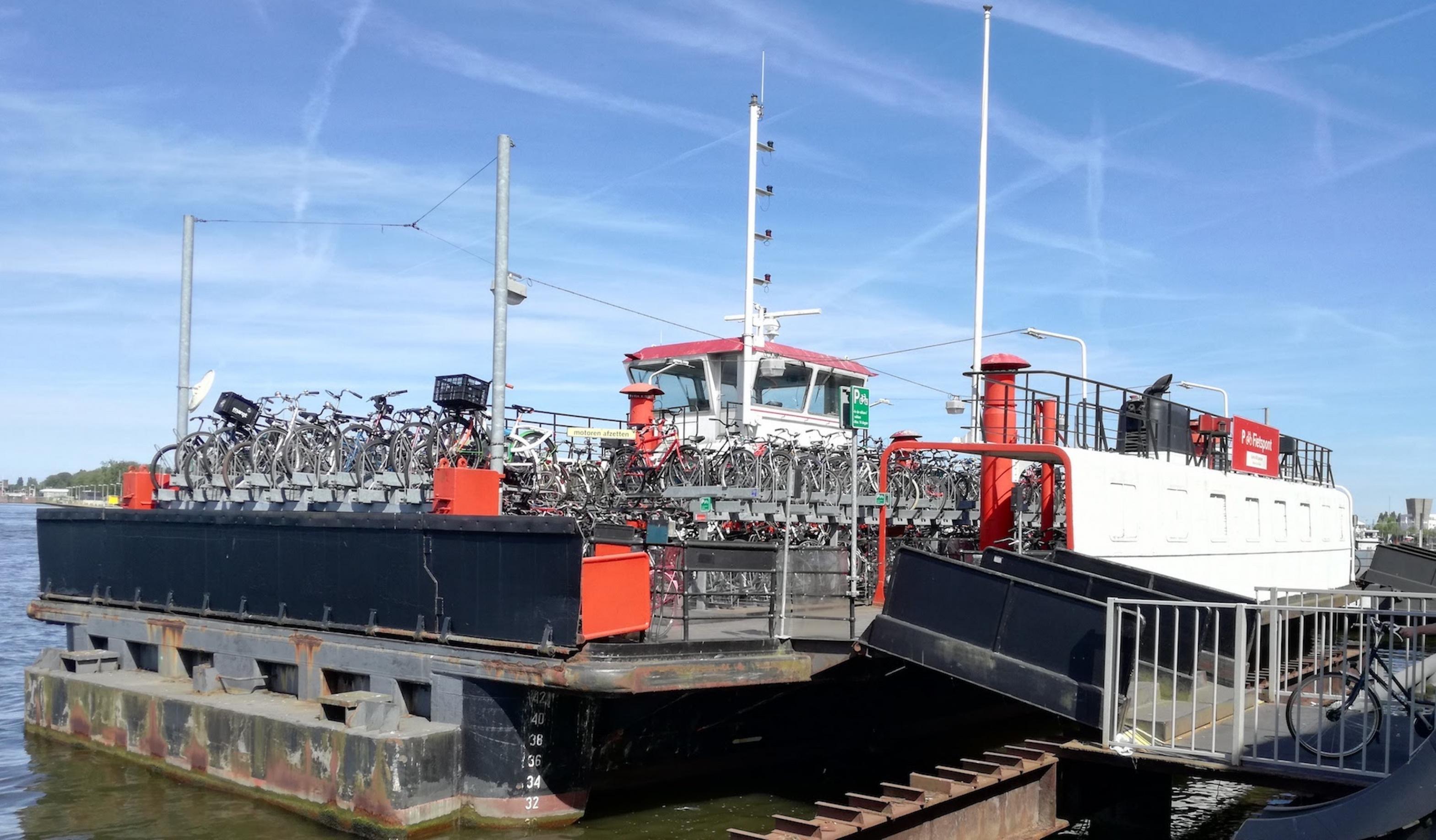 Am Hafen dockt ein Schiff an, das beladen mit Fahrrädern ist.