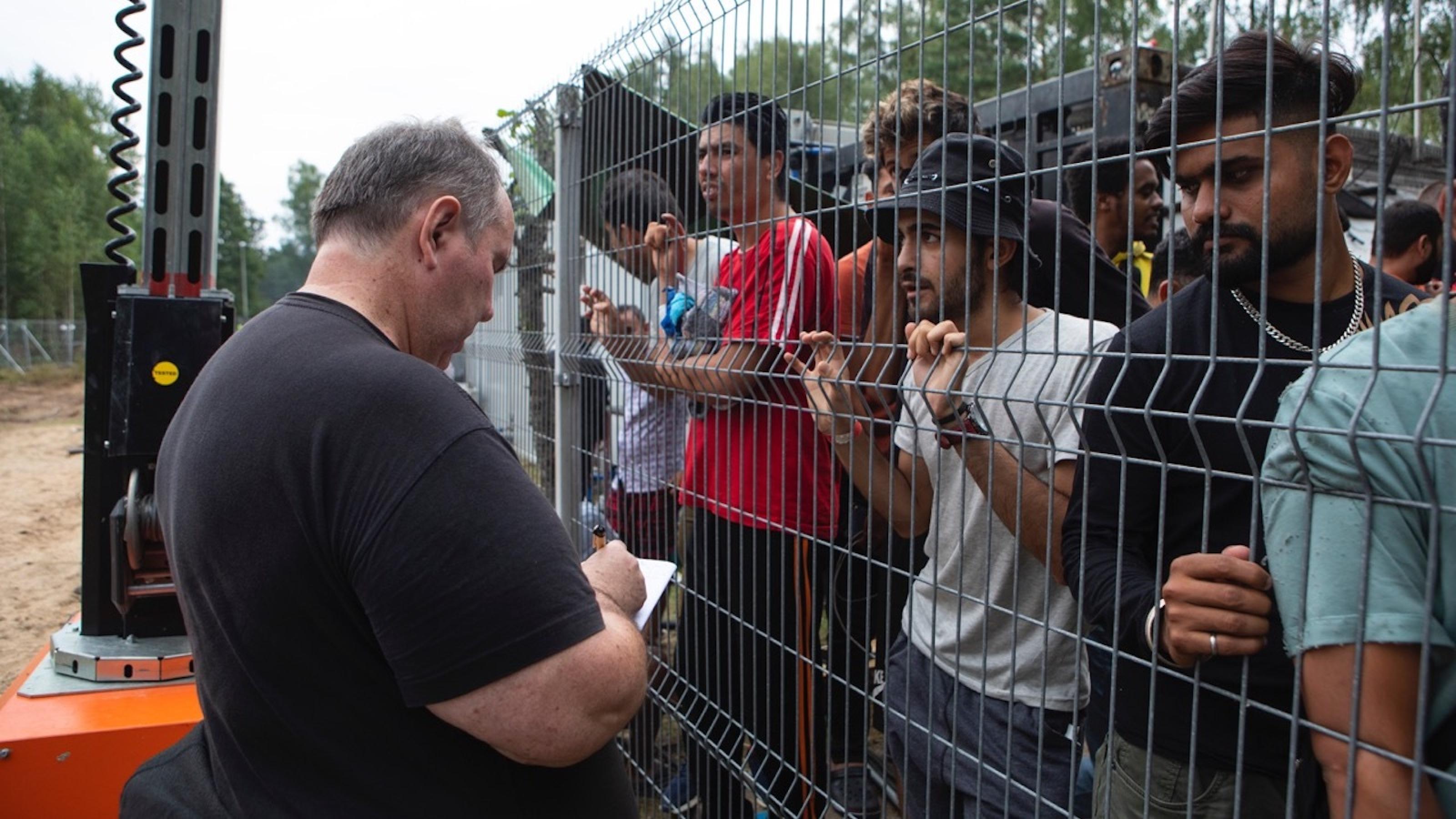 Osteuropa-Korrespondent Paul Flückiger spricht mit Flüchtlingen, die hinter dem litauischen Grenzzaun zu Belarus stehen.