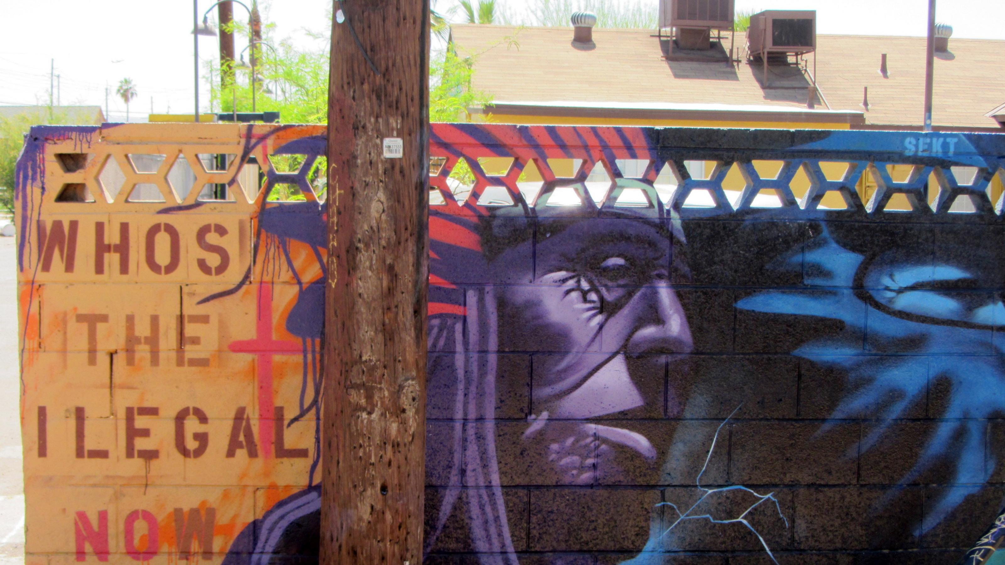 Ein buntes Graffiti an einer Mauer, das einen Indianer abbildet.