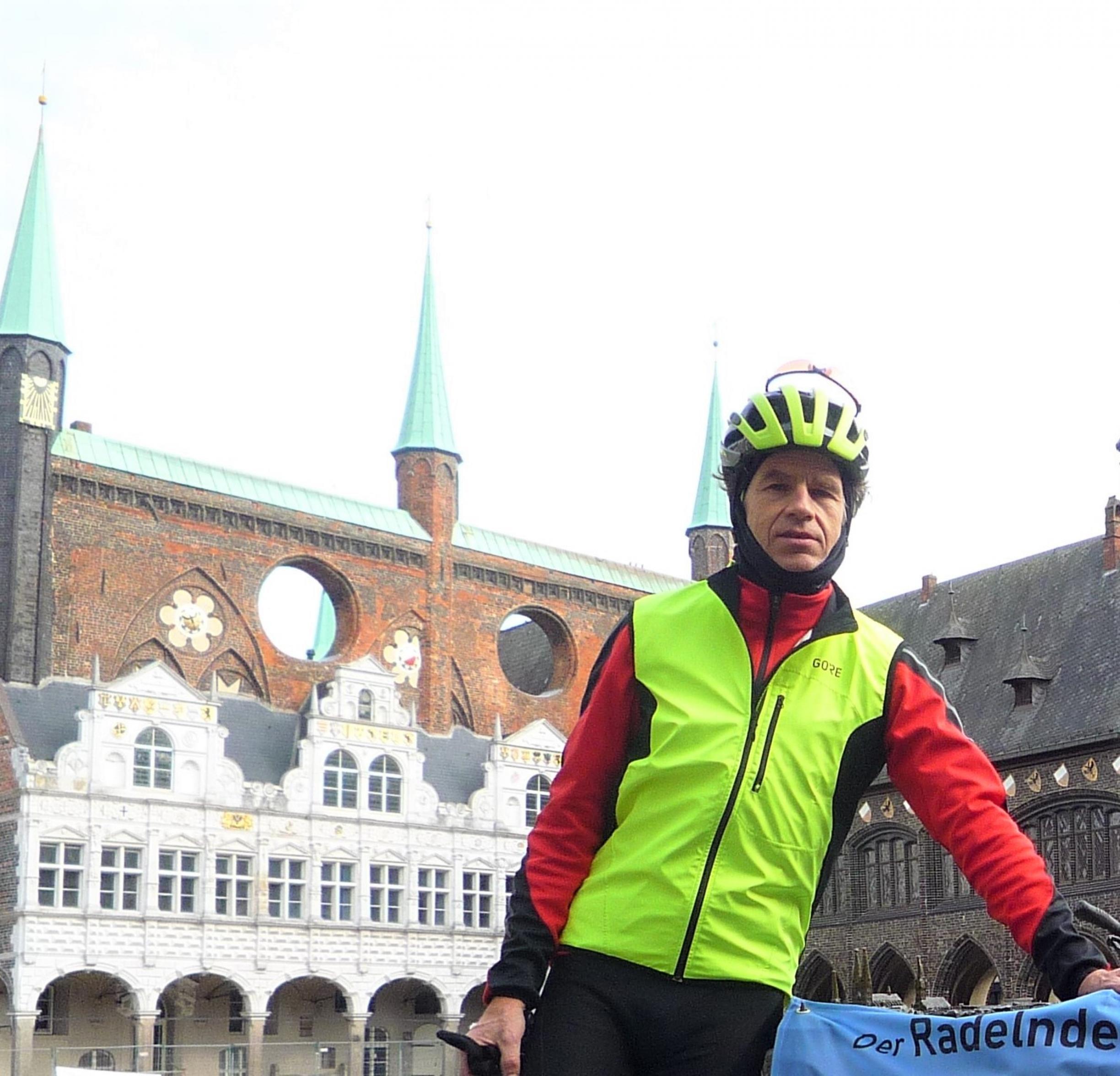 Der RadelndeReporter in Fahrradkluft vor Teilen der Rathauspassage im Hintergrund.