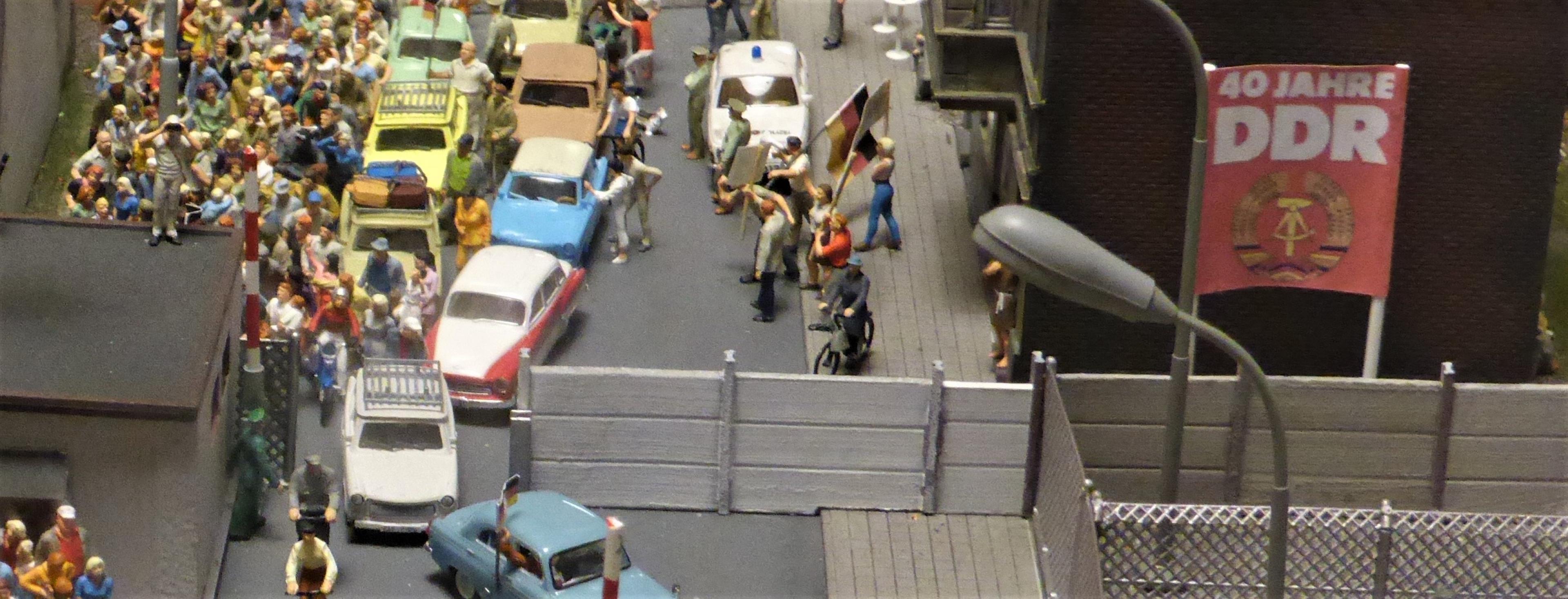 Nachgebaute Szene im Miniaturformat ein einem fiktiven Grenzübergang der Berliner Mauer: neben dem Plakat "40 Jahre DDR schlängelt sich am 9.11.1989 eine Trabikolonne gen Westen.