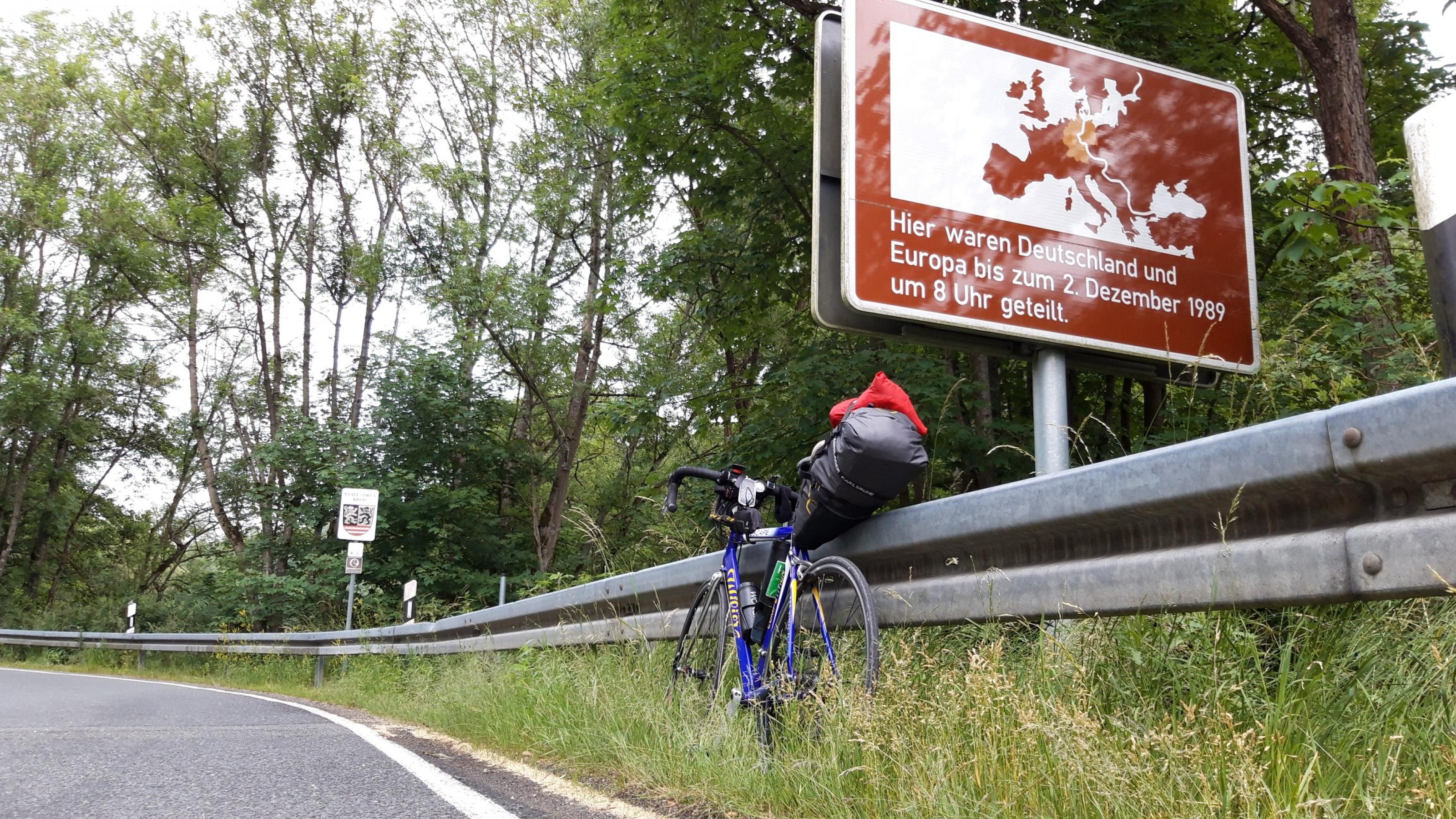 An der Grenze zu Thüringen steht das Schild „Hier waren Deutschland und Europa bis zum 2. Dezember 1989 um 8 Uhr geteilt“.