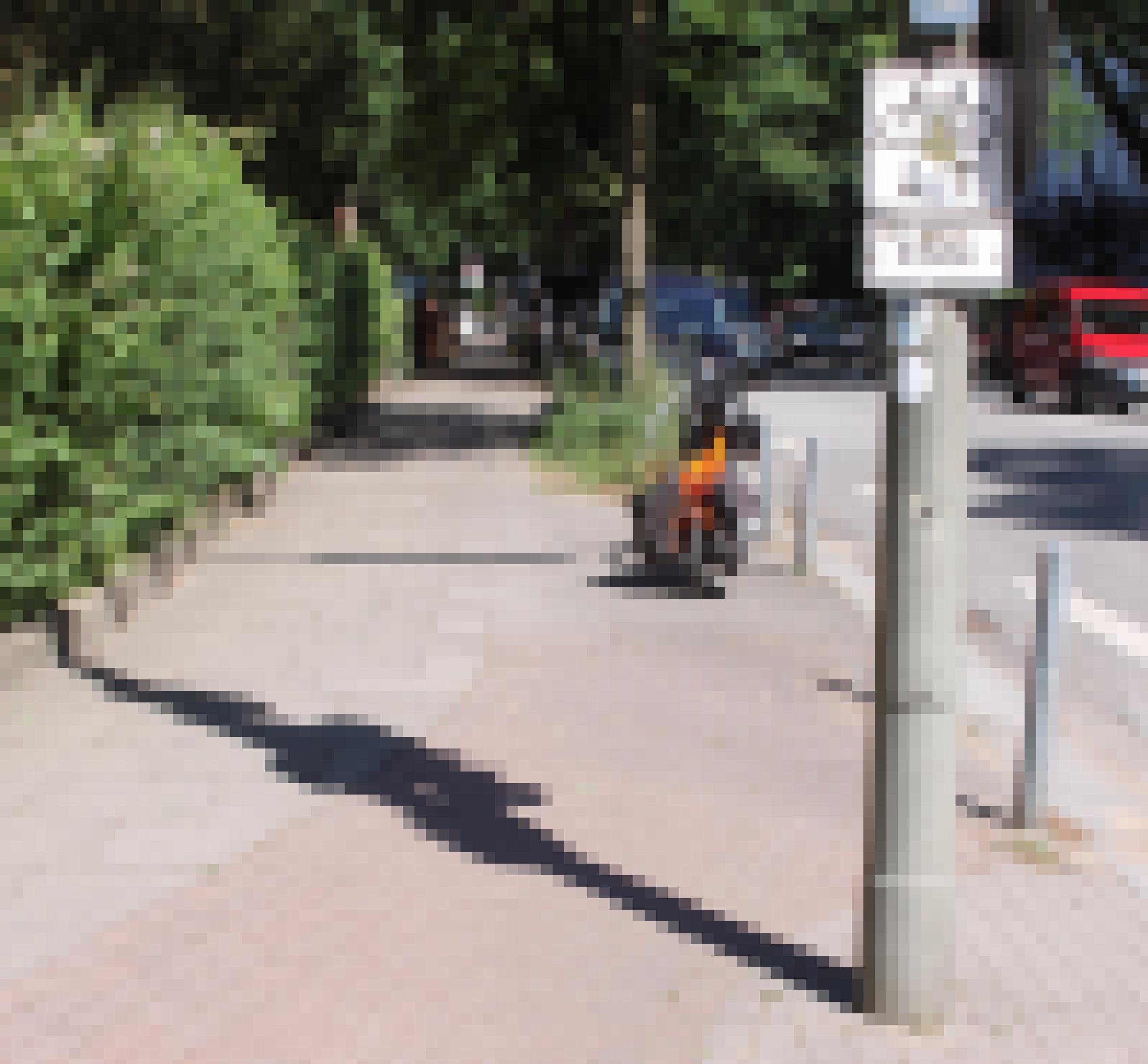 Ein Schild an einem Radweg weist auf dessen Ende hin. Im Hintergrund ist ein orangefarbenes, parkendes Mofa zu sehen.