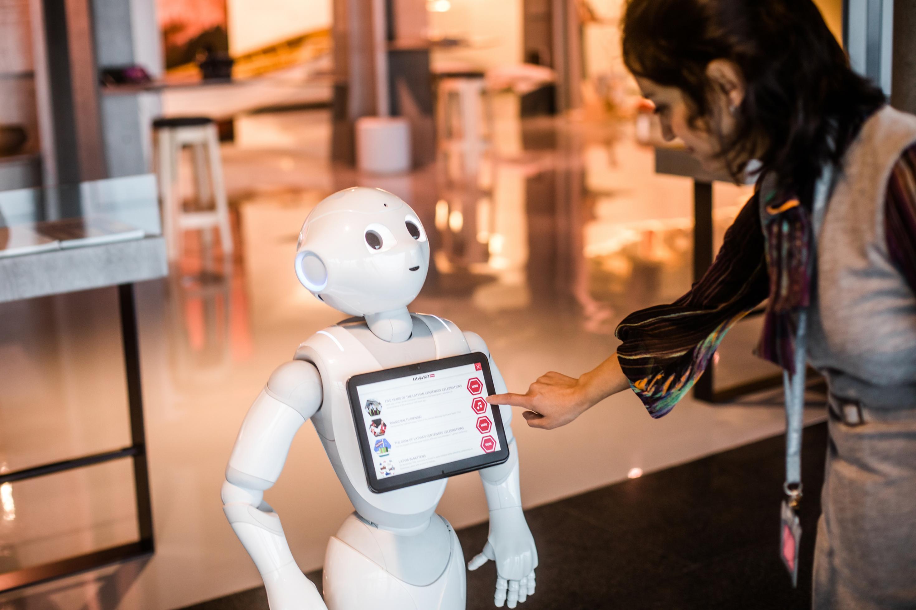 Ein Passagier erkundigt sich bei Roboter Pepper am Flughafen von Riga. Dank KI können Maschinen die Rolle eines sozialen Gegenübers übernehmen.