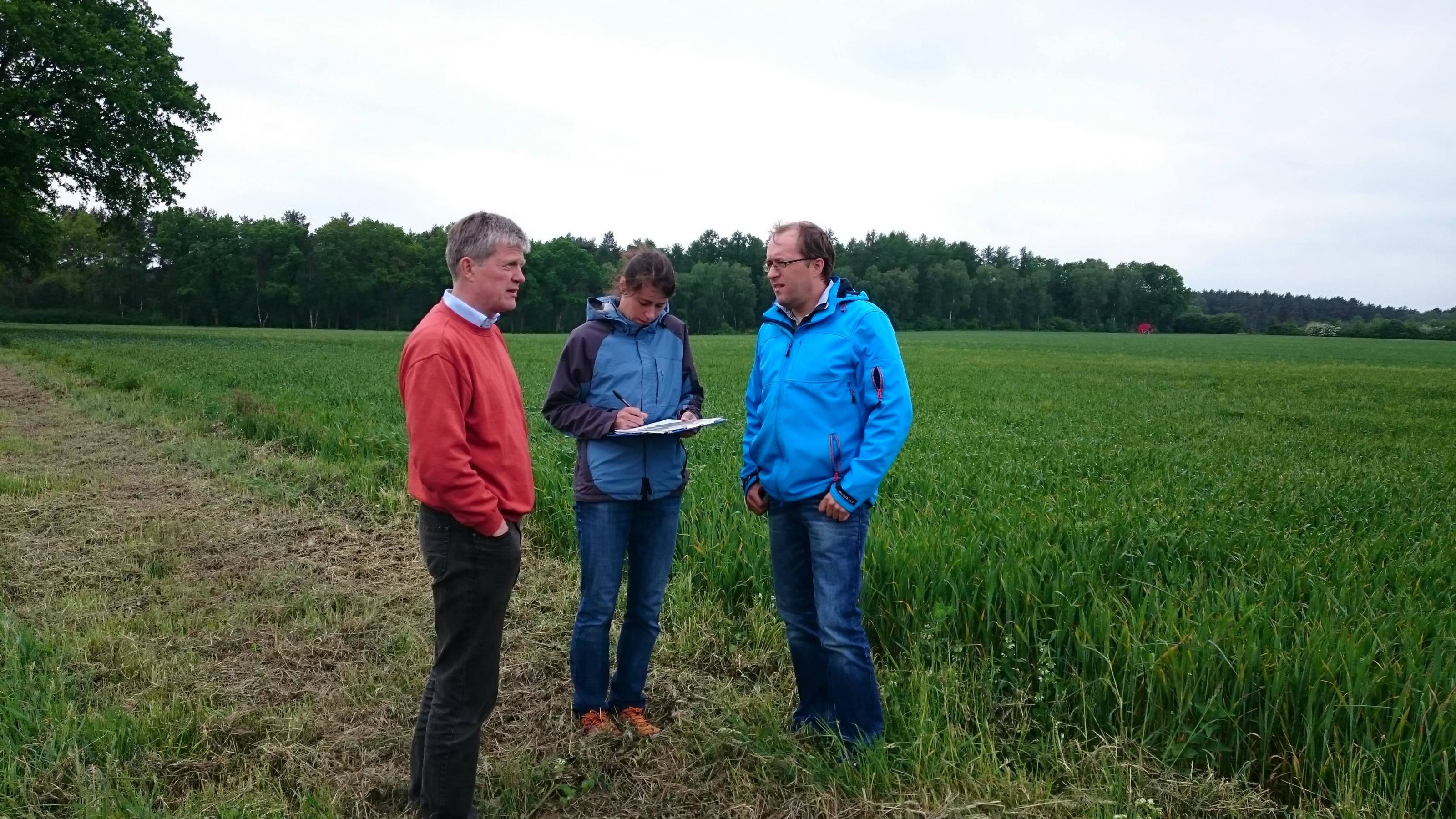 Landwirt Jochen Hartmann (rechts) und Björn Rohloff beraten gemeinsam mit der Biologin Laura Sutcliffe.
