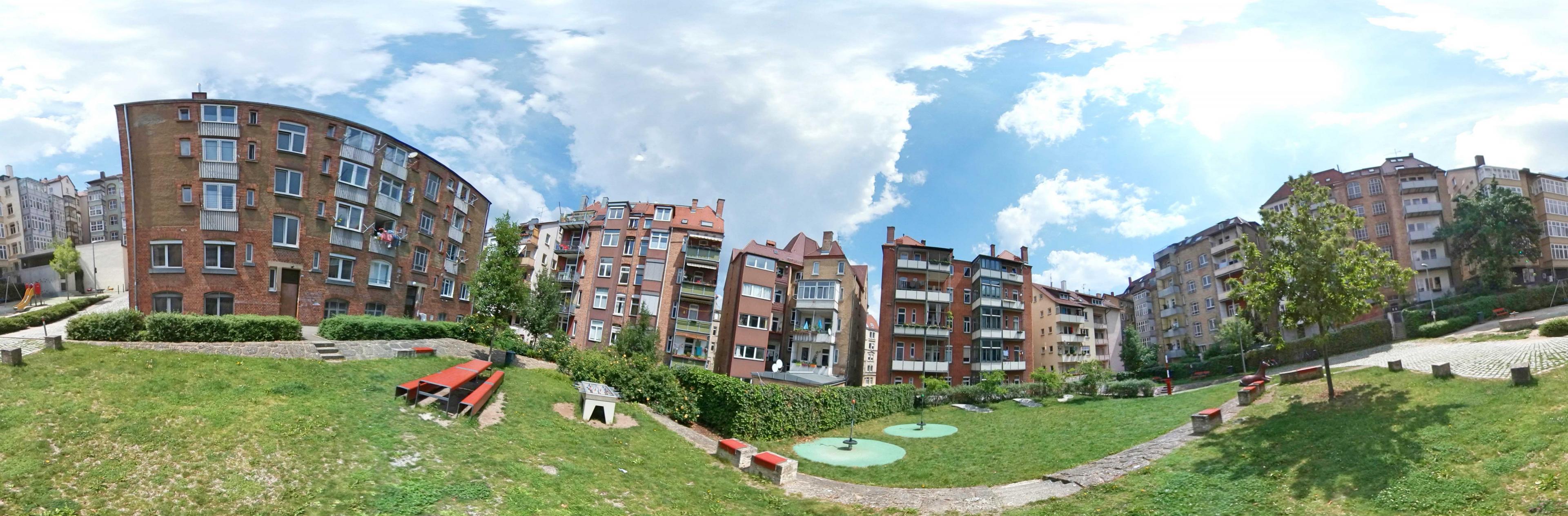 Das Rossbollengässle in Stuttgart – hier als 360-Grad-Panorama – zeigt musterhaft, wie sich die Stadt auf ein wärmeres Klima einstellen kann: Die Bäume im Innenhof werden einmal Jung und Alt Schatten spenden und die begrünte Fläche heizt sich nicht so stark auf. Unter den Spielgeräten und Sitzbänken liegt eine Tiefgarage für die Anwohner.