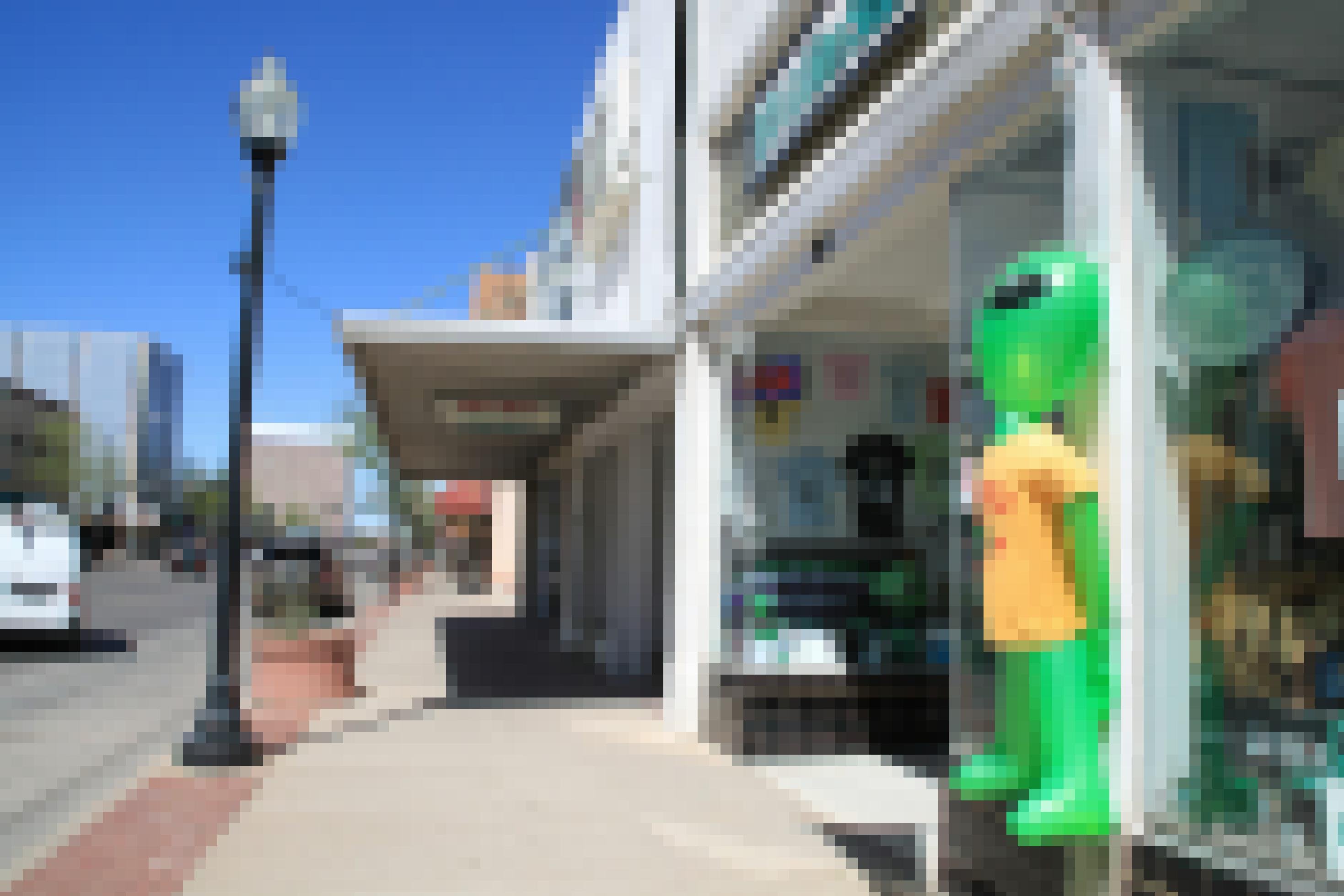 Auf einer Einkaufsstraße steht ein aufblasbarer Außerirdischer vor einem Geschäft