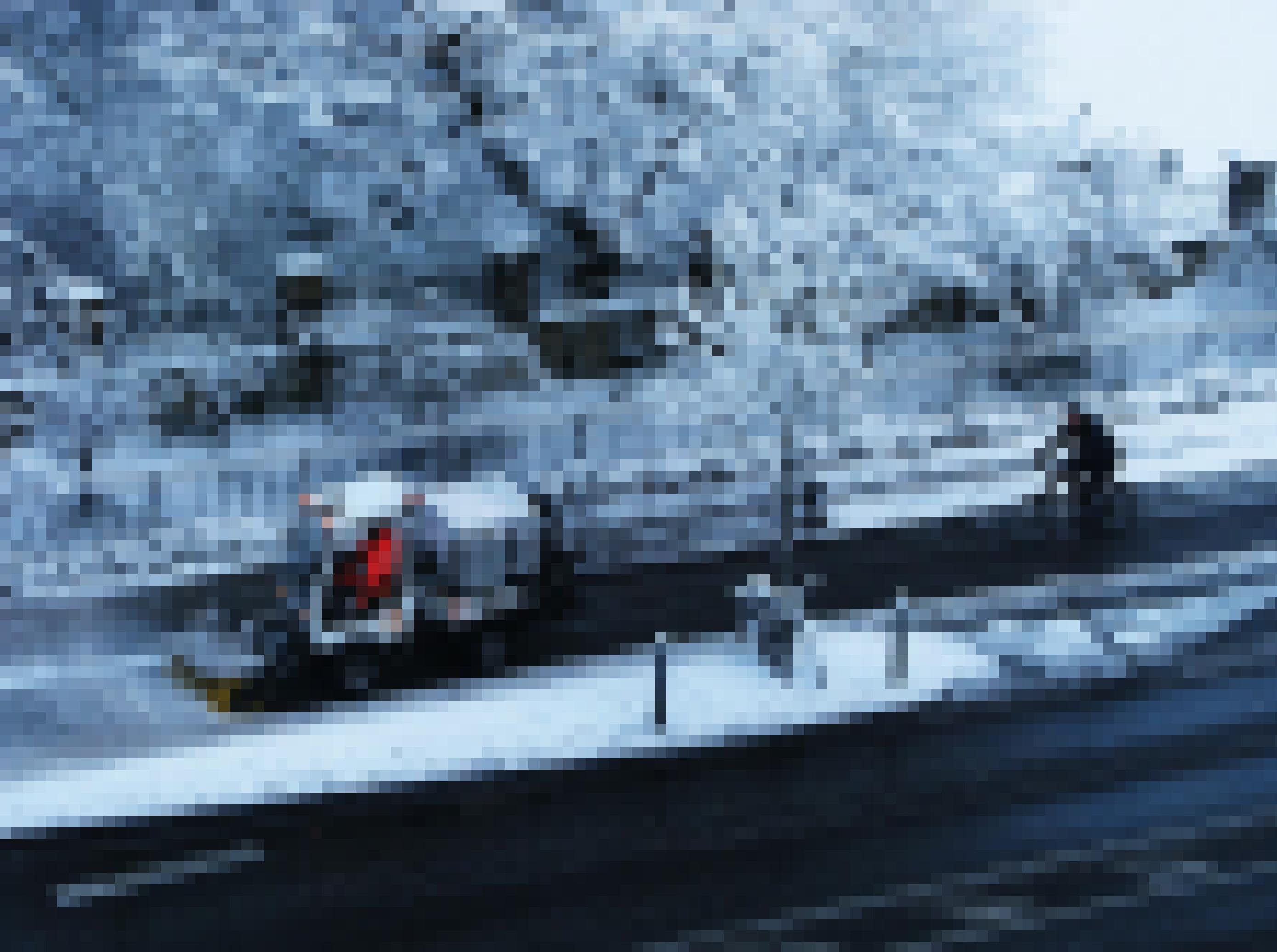 Ein Schneepflug räumt einen verschneiten Radweg.