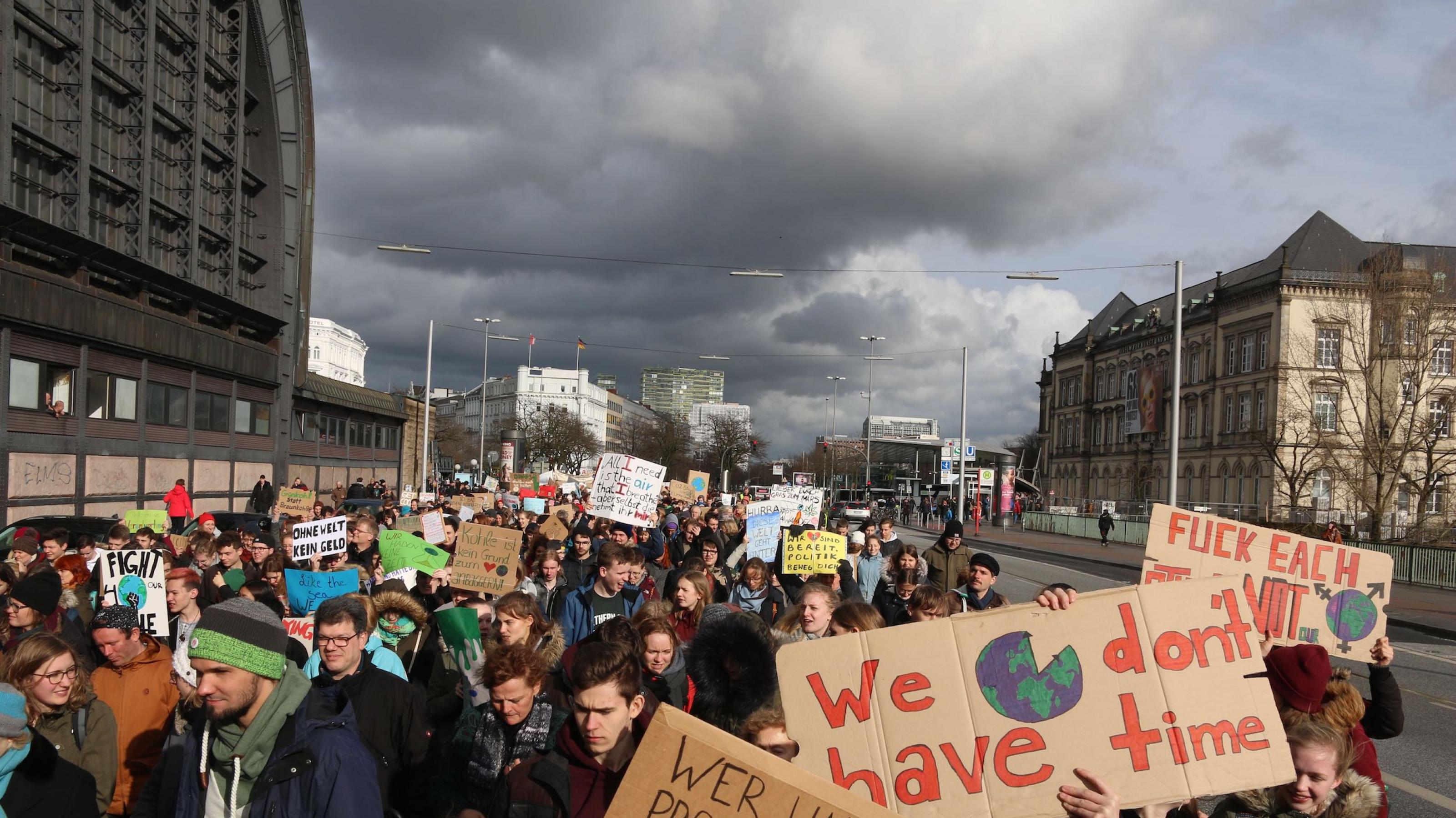 Schüler streiken für Klimaschutz am 15. März in Hamburg, einem Ferientag. Die Sonne scheint über dem Demonstrationszug, doch am Horizont sammeln sich dunkle Wolken.