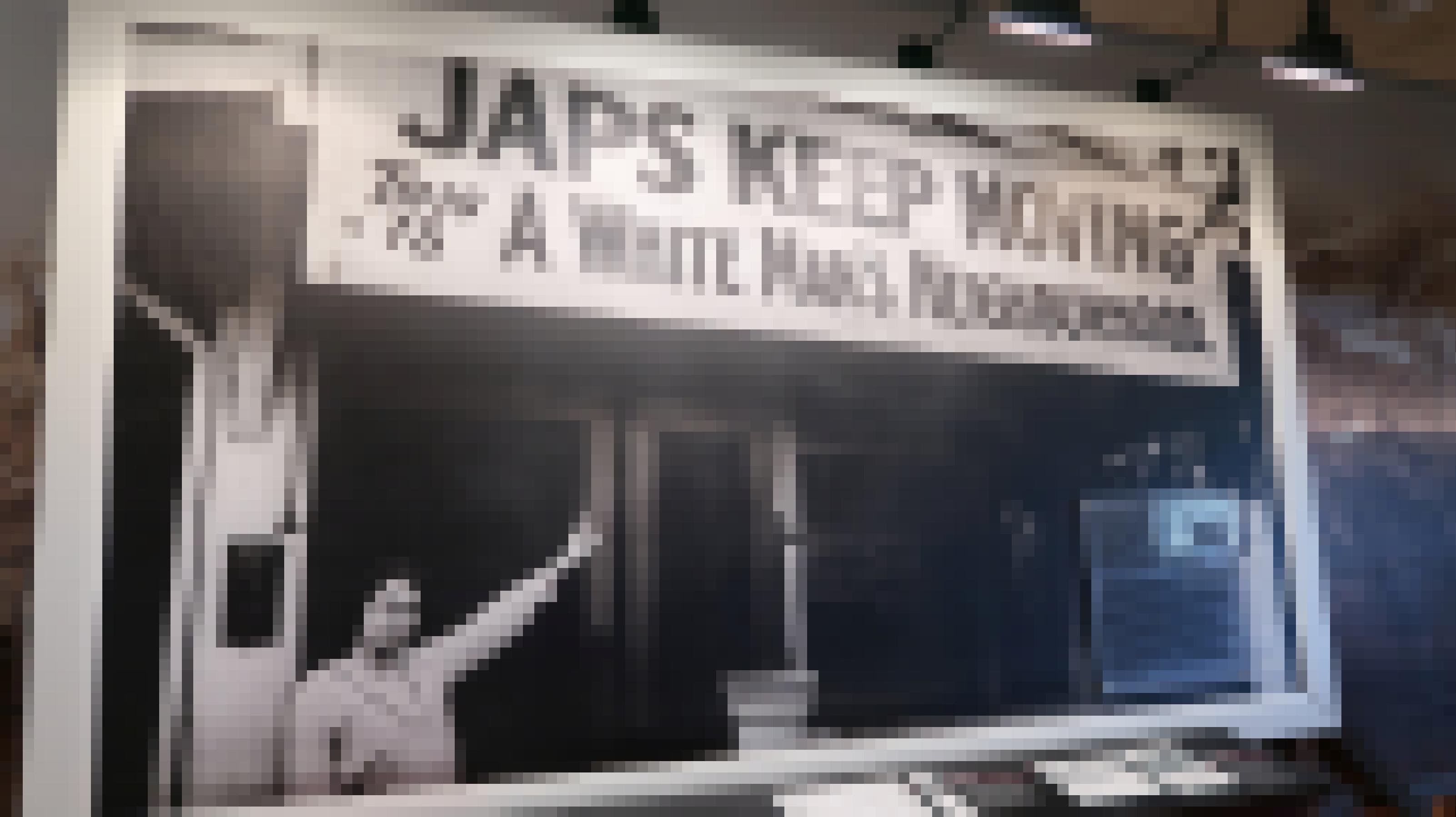 Ein gerahmtes Schwarzweiß-Foto eine Frau, die auf ein Schild mit der Aufschrift „Japs keep moving: This is a White Man's Neighborhood“ zeigt.