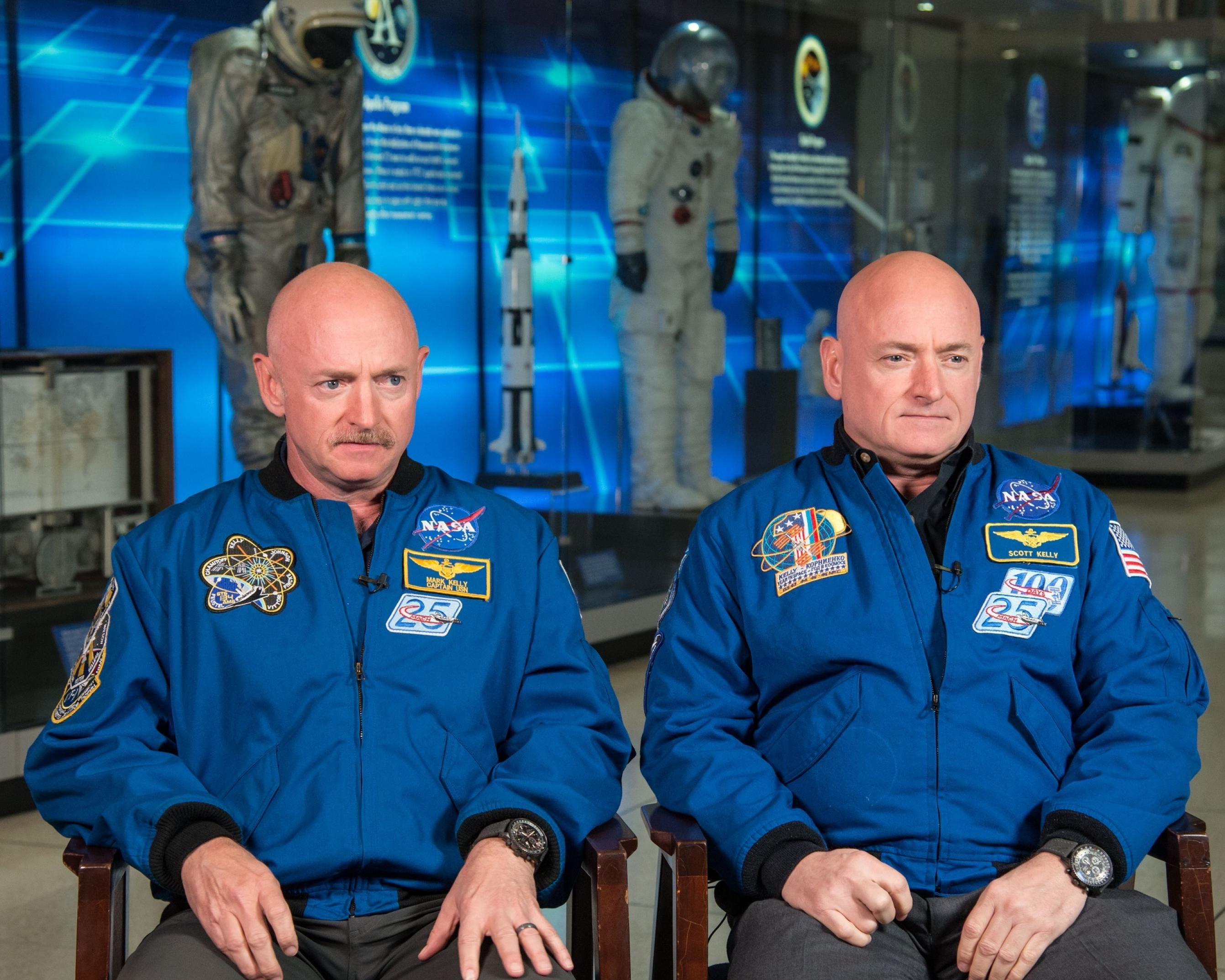 Die eineiigen Zwillinge Scott und Mark Kelly schauen in die Kamera. Englischer Erklärungstext der NASA: Expedition 45/46 Commander, Astronaut Scott Kelly along with his brother, former Astronaut Mark Kelly speak to news media outlets about Scott Kelly's 1-year mission aboard the International Space Station.  Photo Date: January 19, 2015.  Location: Building 2.