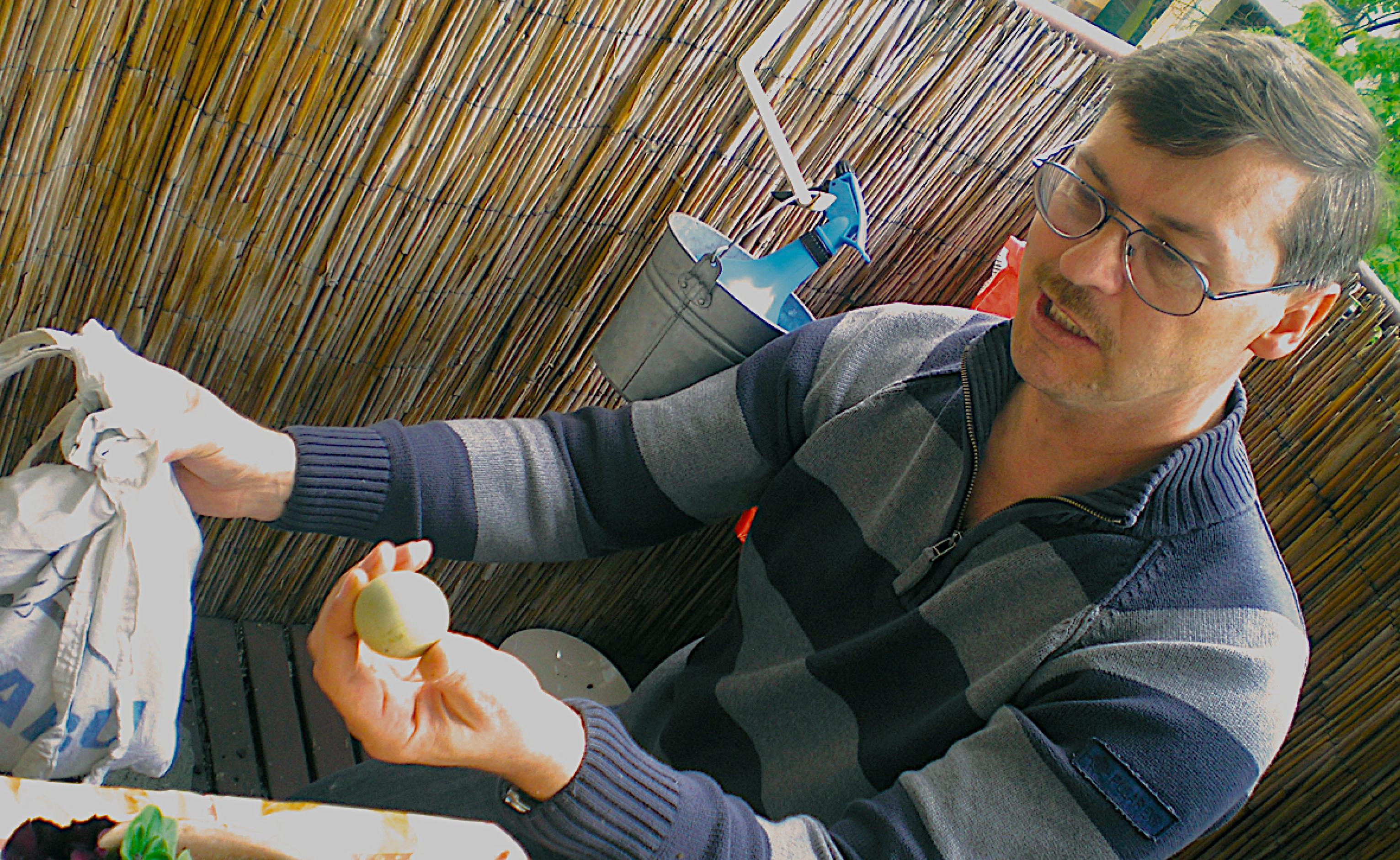 Ein Biologe hält ein Enten-Ei in der Hand.