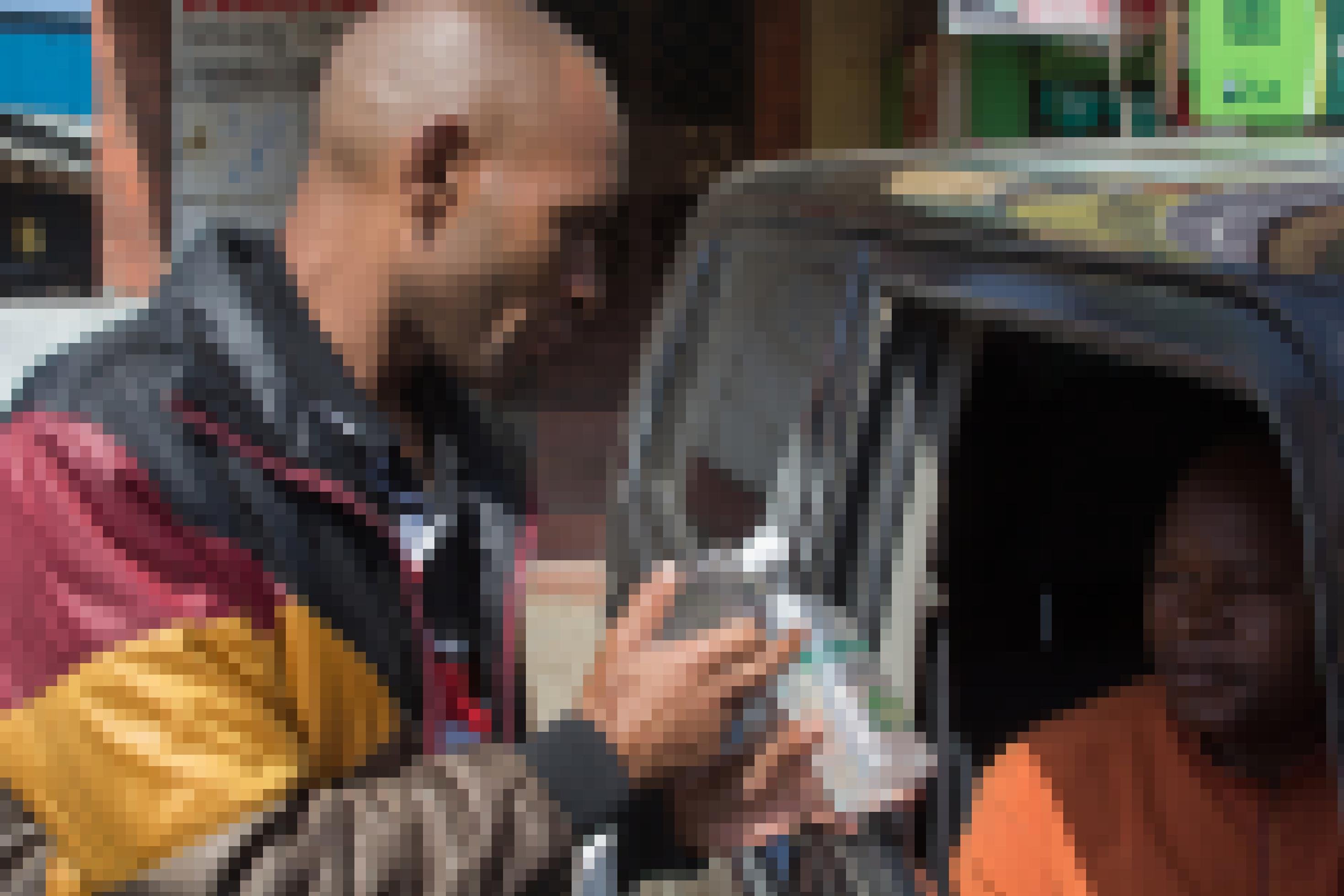 Ein Strassenhändler hält eine Flasche Desinfektionsmittel in ein offenes Autofenster