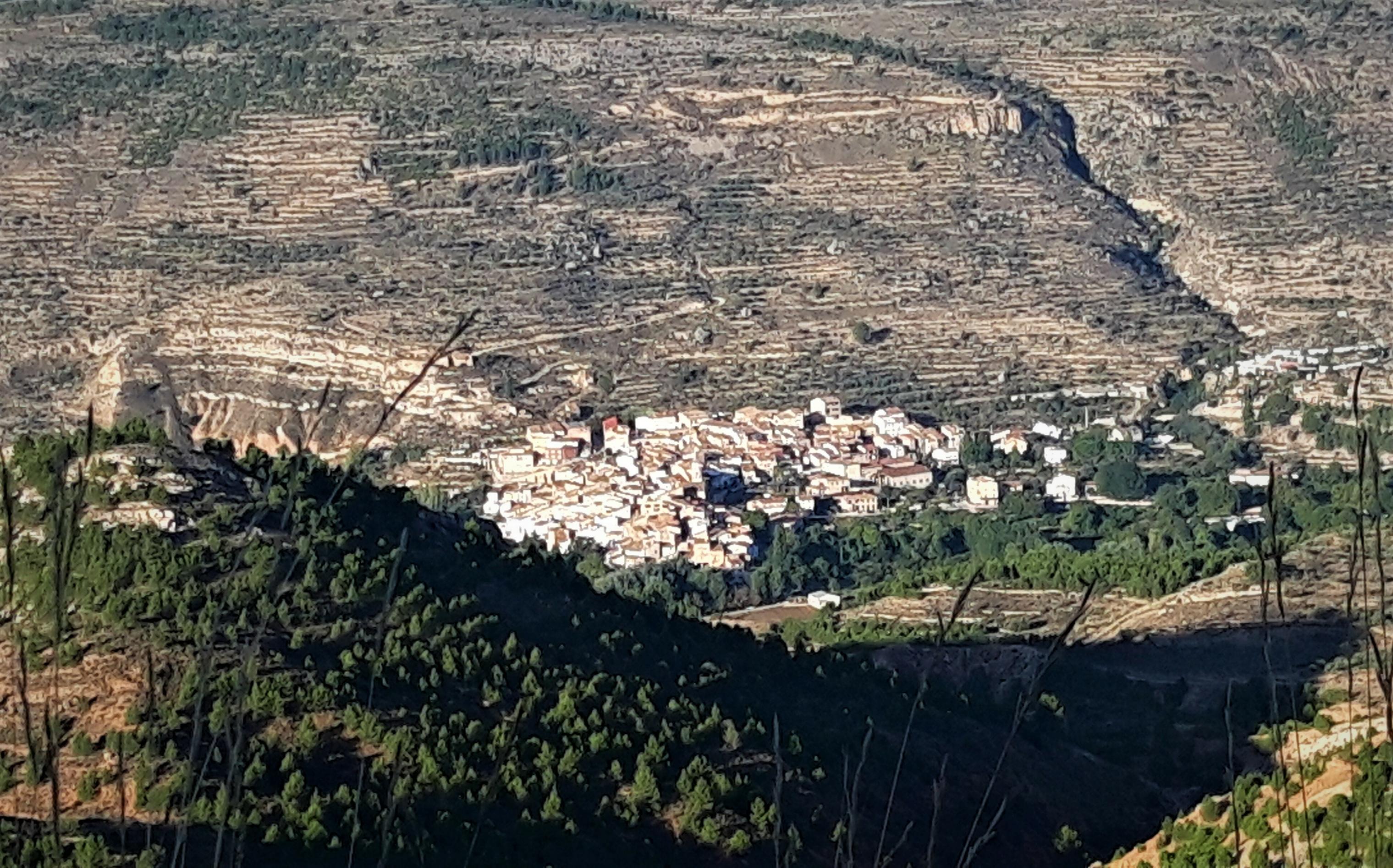 Bergdorf inmitten eher karger Gebirgslandschaft.