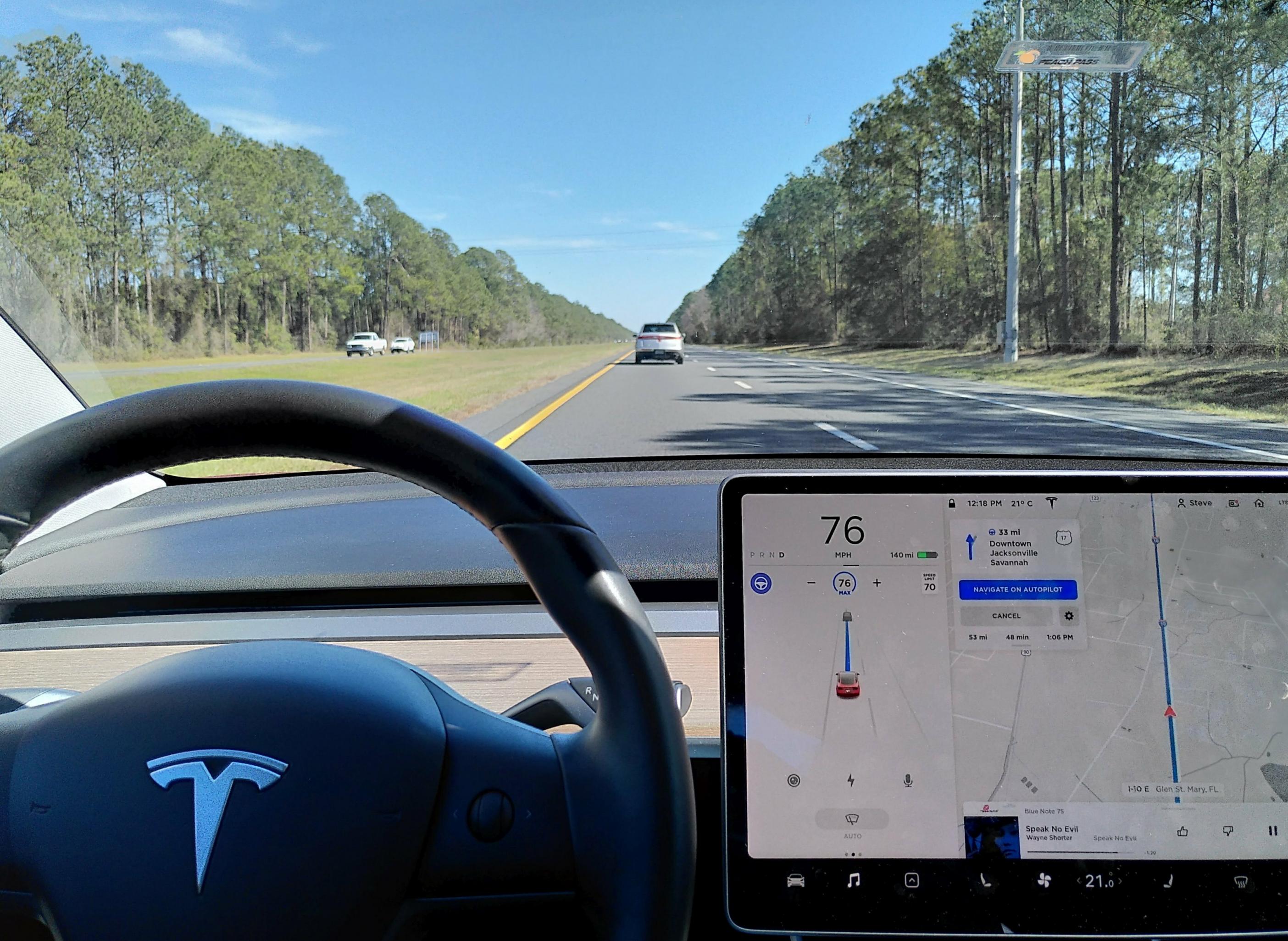 Blick aufs Armaturenbrett eines Teslas während der Fahrt.