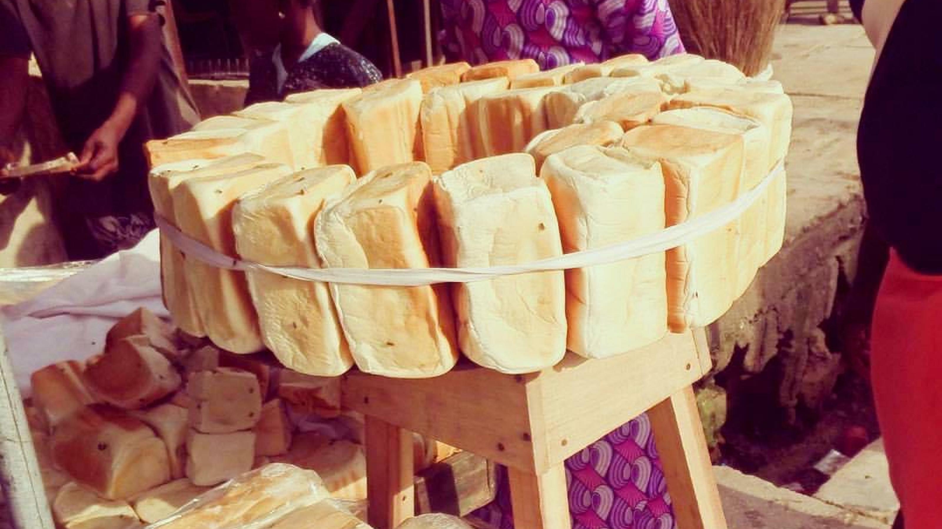 Ein Brotverkäufer steht neben Laiben des beliebten Agege-Brotes in Lagos, Nigeria