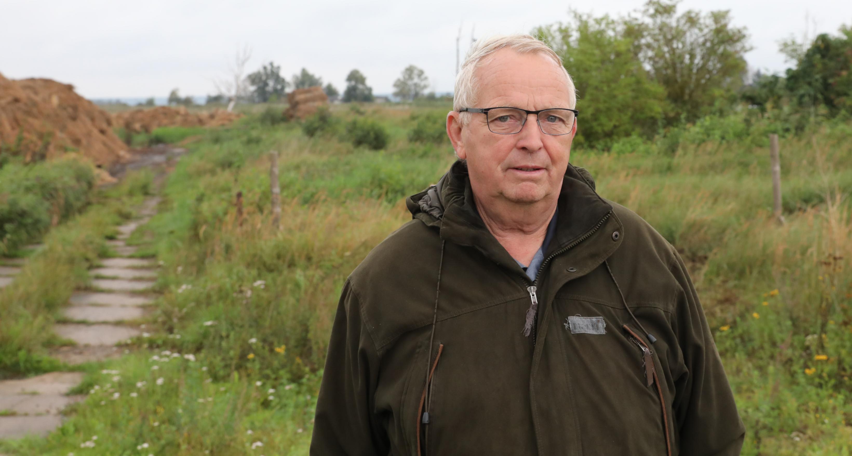 Backhaus steht im Anorak im Moor