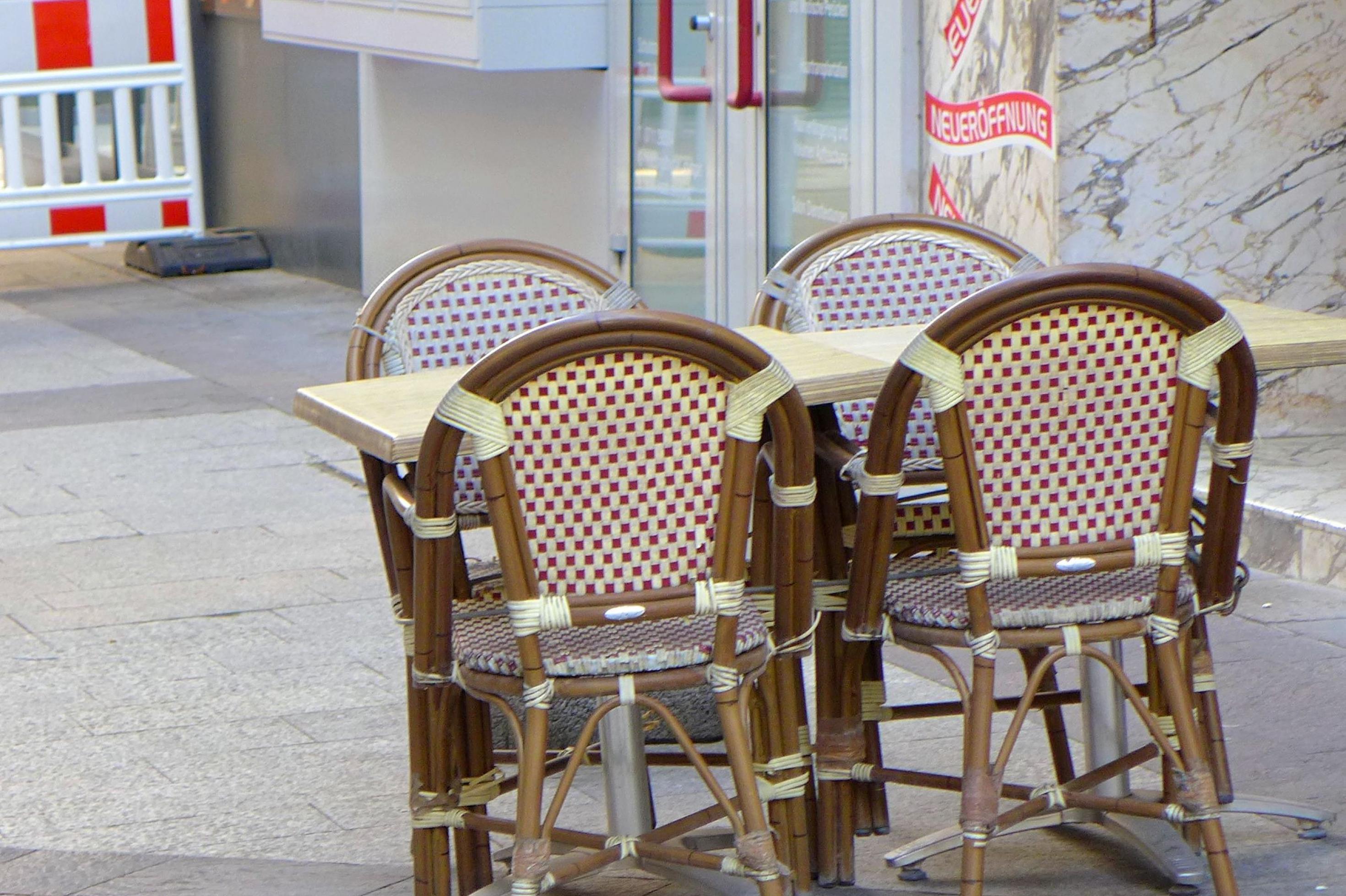 Ein leerer Tisch steht vor einem geschlossenen Restaurant.