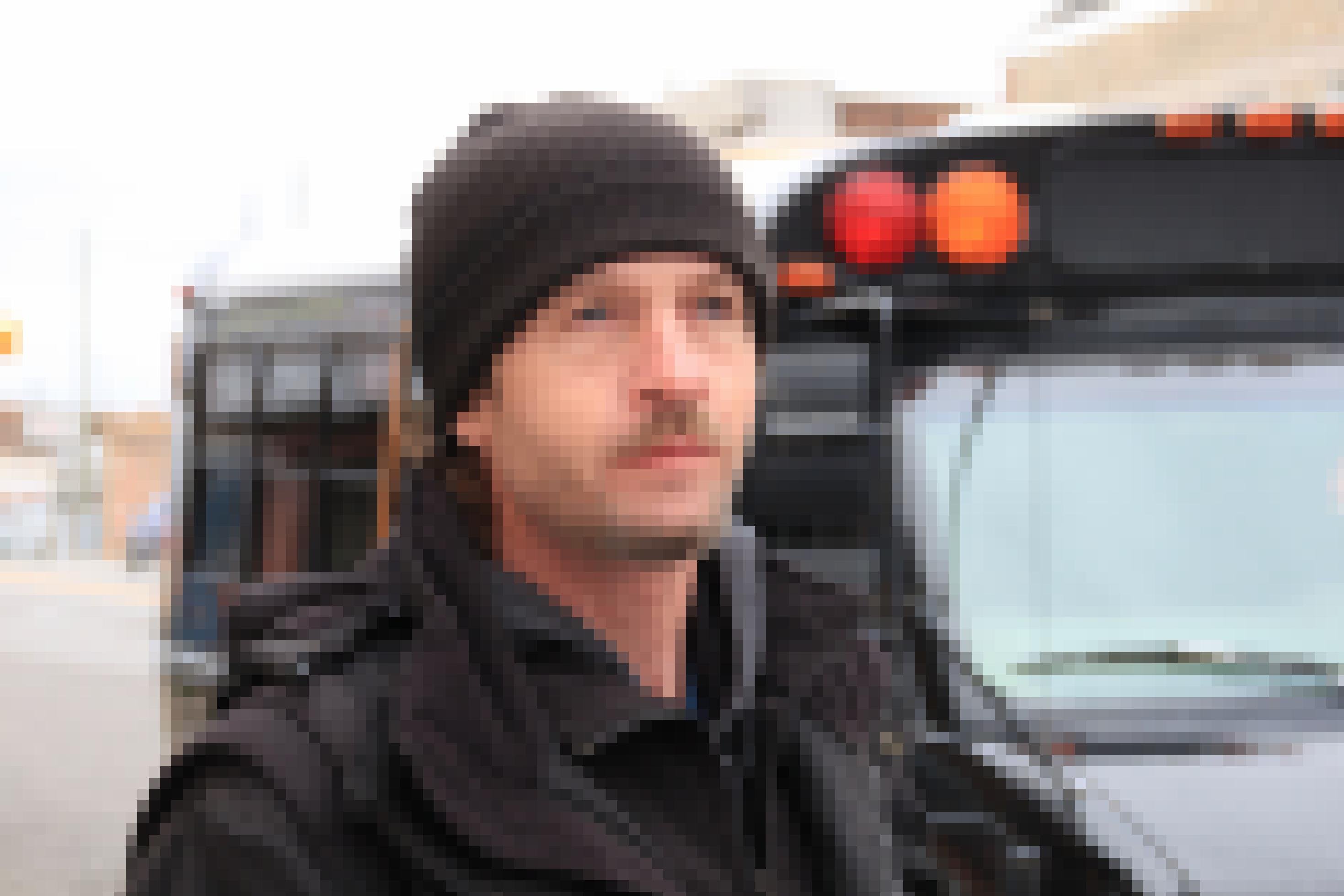 Ein Mann mit Mütze vor einem Bus