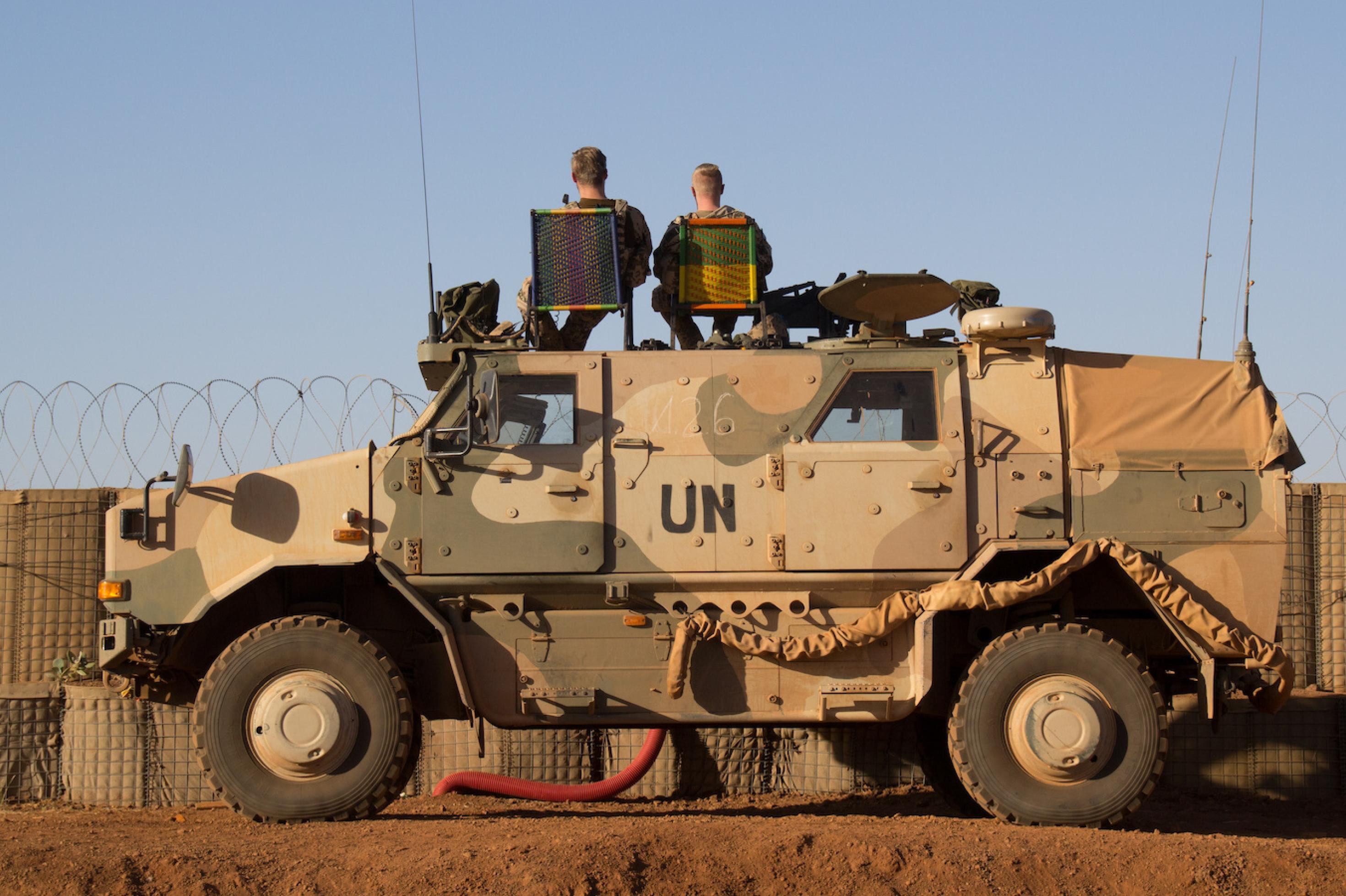 Zwei Bundeswehrsoldaten sitzen auf einem UN-Panzerfahrzeug in Mali