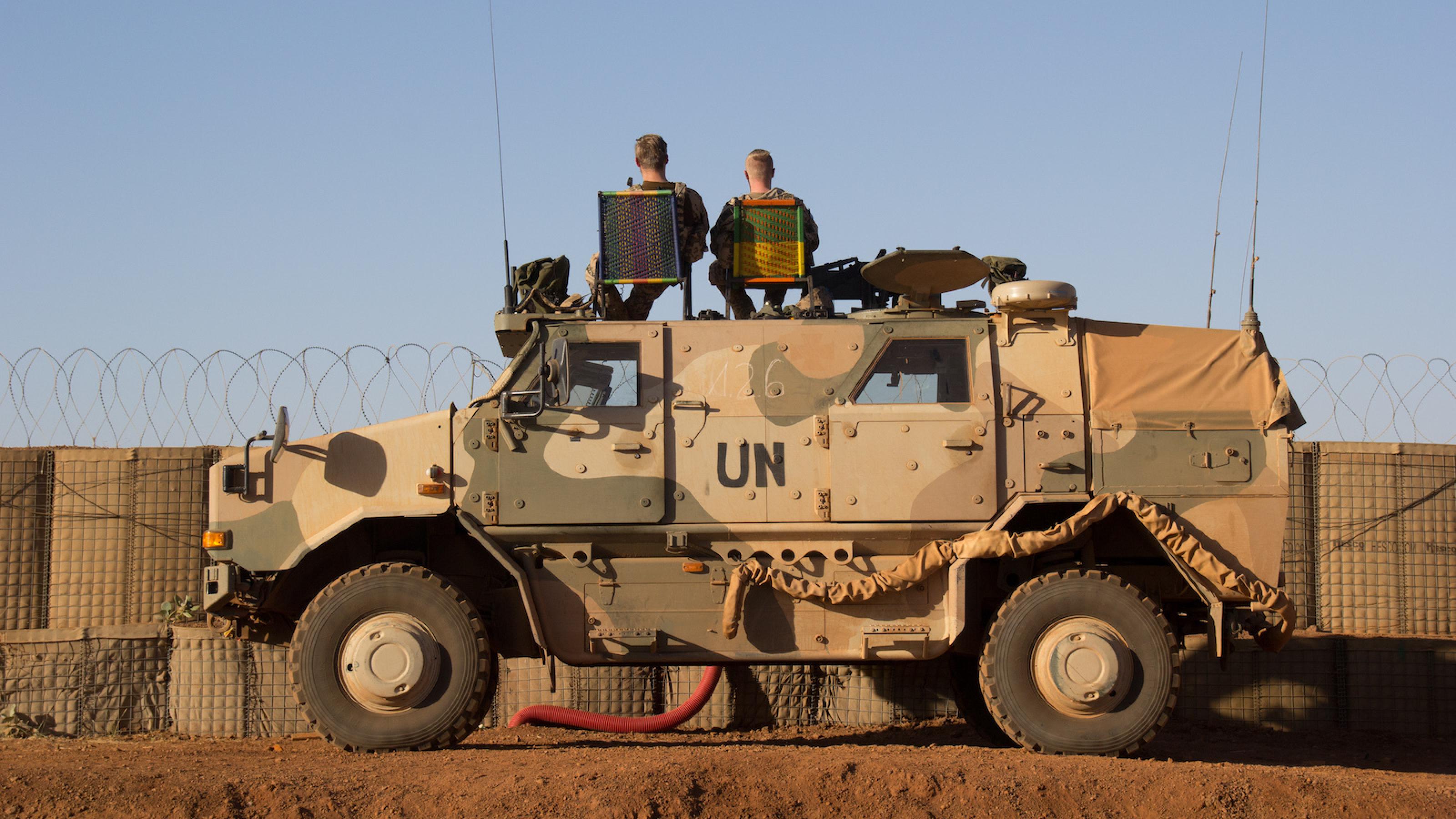 Zwei Bundeswehrsoldaten sitzen auf einem UN-Panzerfahrzeug in Mali