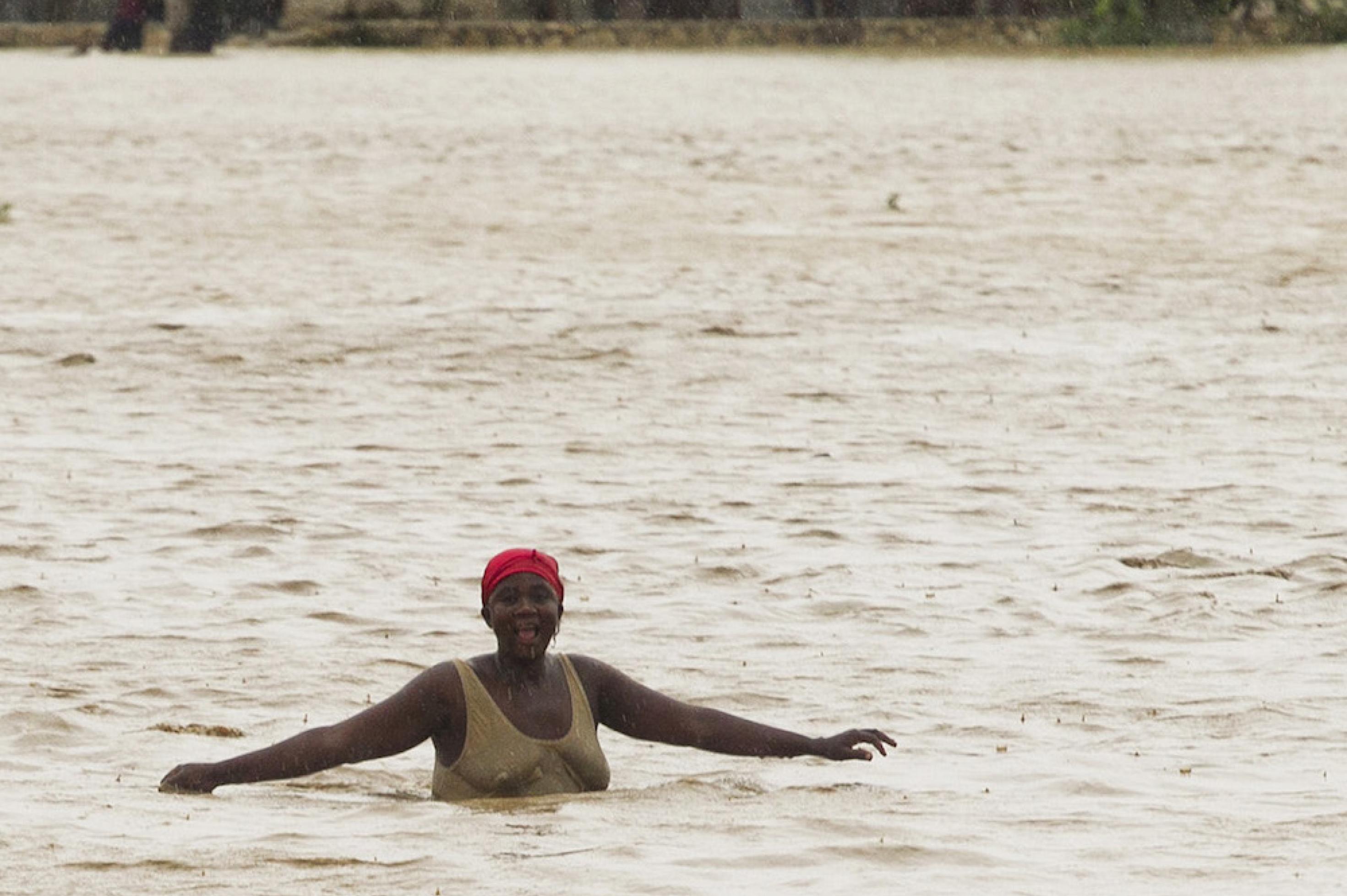 Eine Frau watet durch eine brusthohe Wasserfläche. Als der Tropensturm Isaac 2012 Haiti erfasste, da liefen schnell die tieferliegenden Teil der Hauptstadt Port-au-Prince voll – wo auch immer noch viele Opfer des Erdbebens zwei Jahre zuvor in Lagern hausten.