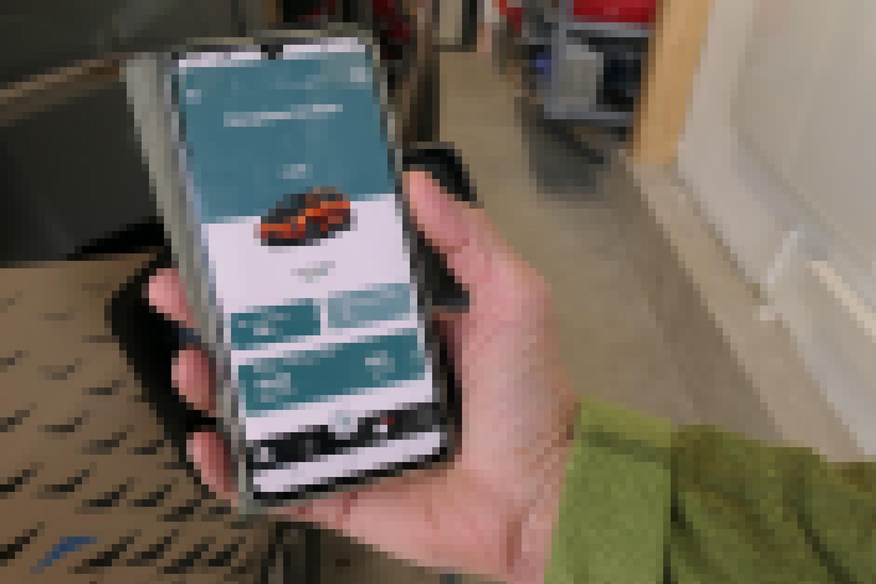 Das Bild zeigt den Arm von Xaver Pfab, die Hand hält ein Smartphone, darauf die App zur Steuerung der Ladevorgänge.