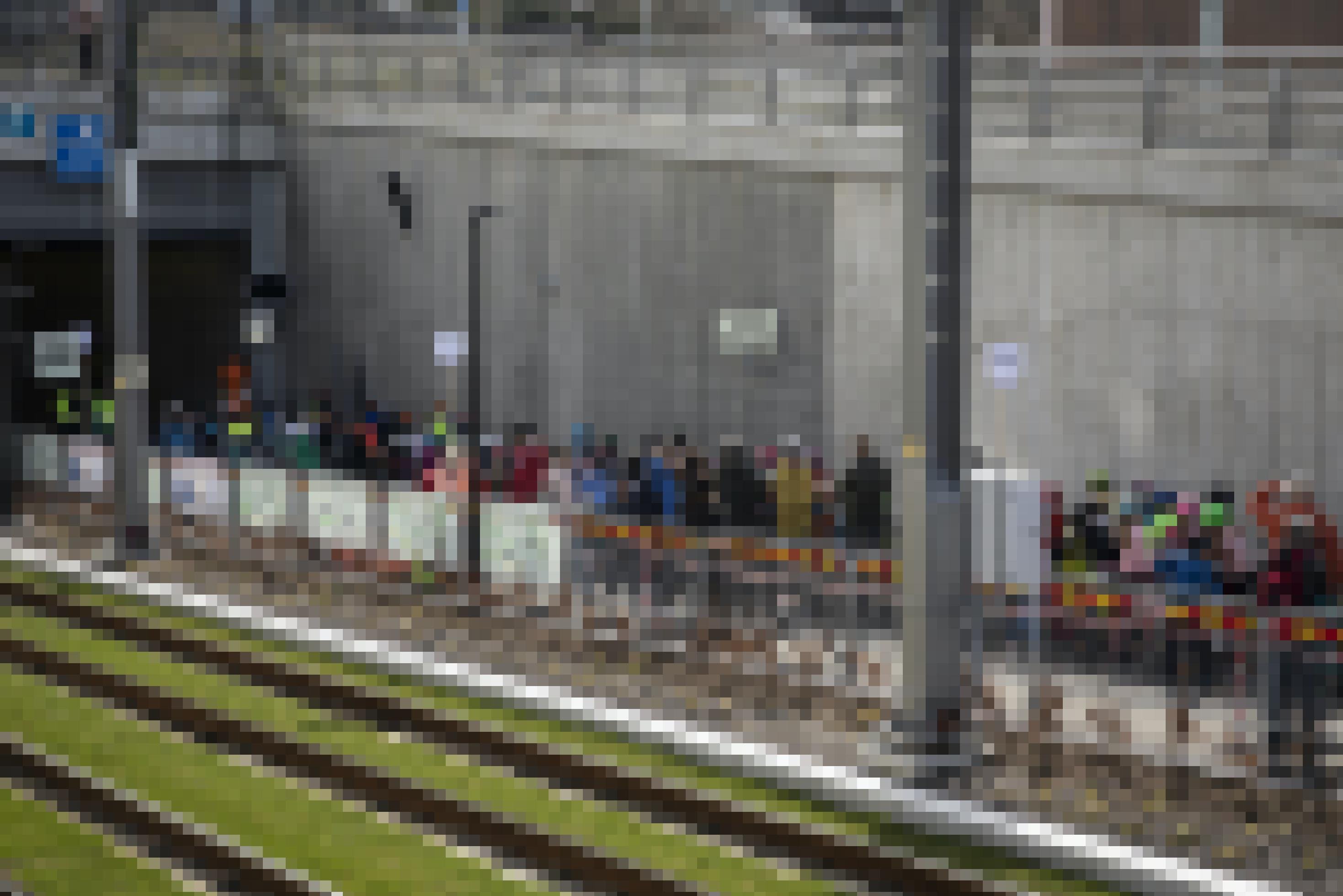 Kinder auf Fahrrädern und Erwachsene stehen vor einer Tunnelöffnung