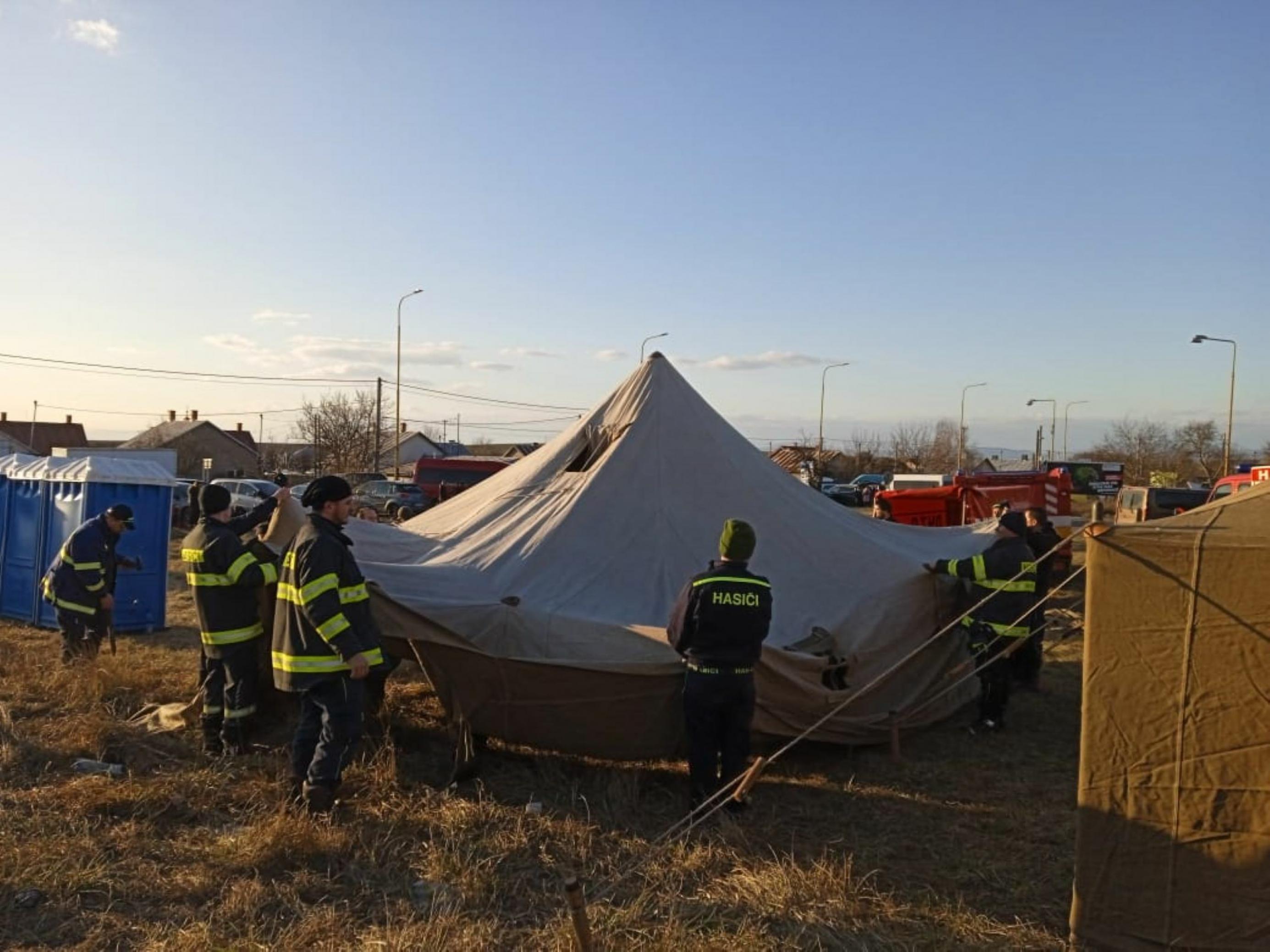 Mehrere Männer bauen im Grenzdorf Vyzhne Nemecke ein Zelt auf, um Geflüchtete aus der Ukraine unterzubringen