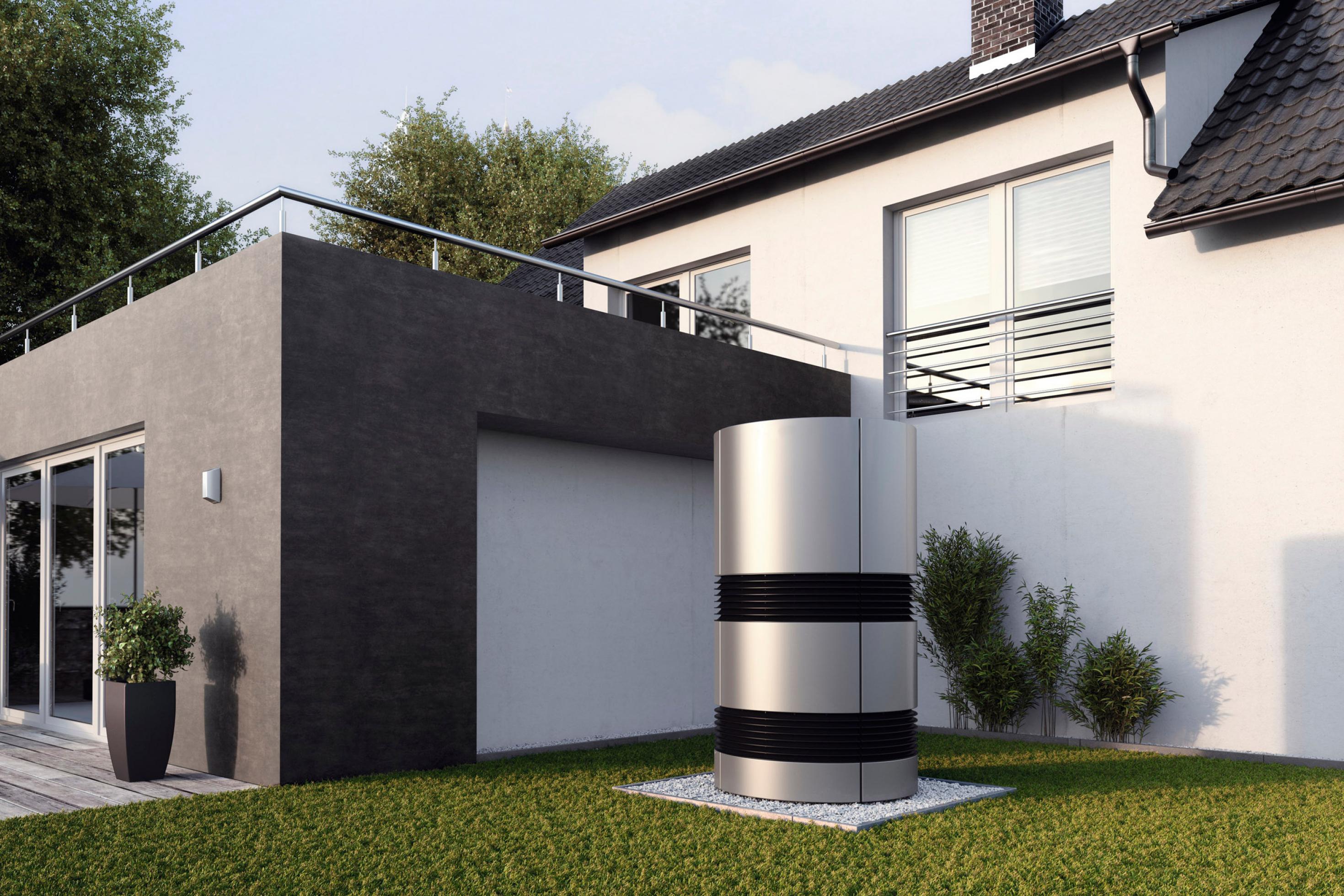 Modernes Einfamilienhaus, Gartenansicht. Im Vordergrund ein rundes, menschenhohes Außengerät einer Klimaanlage.