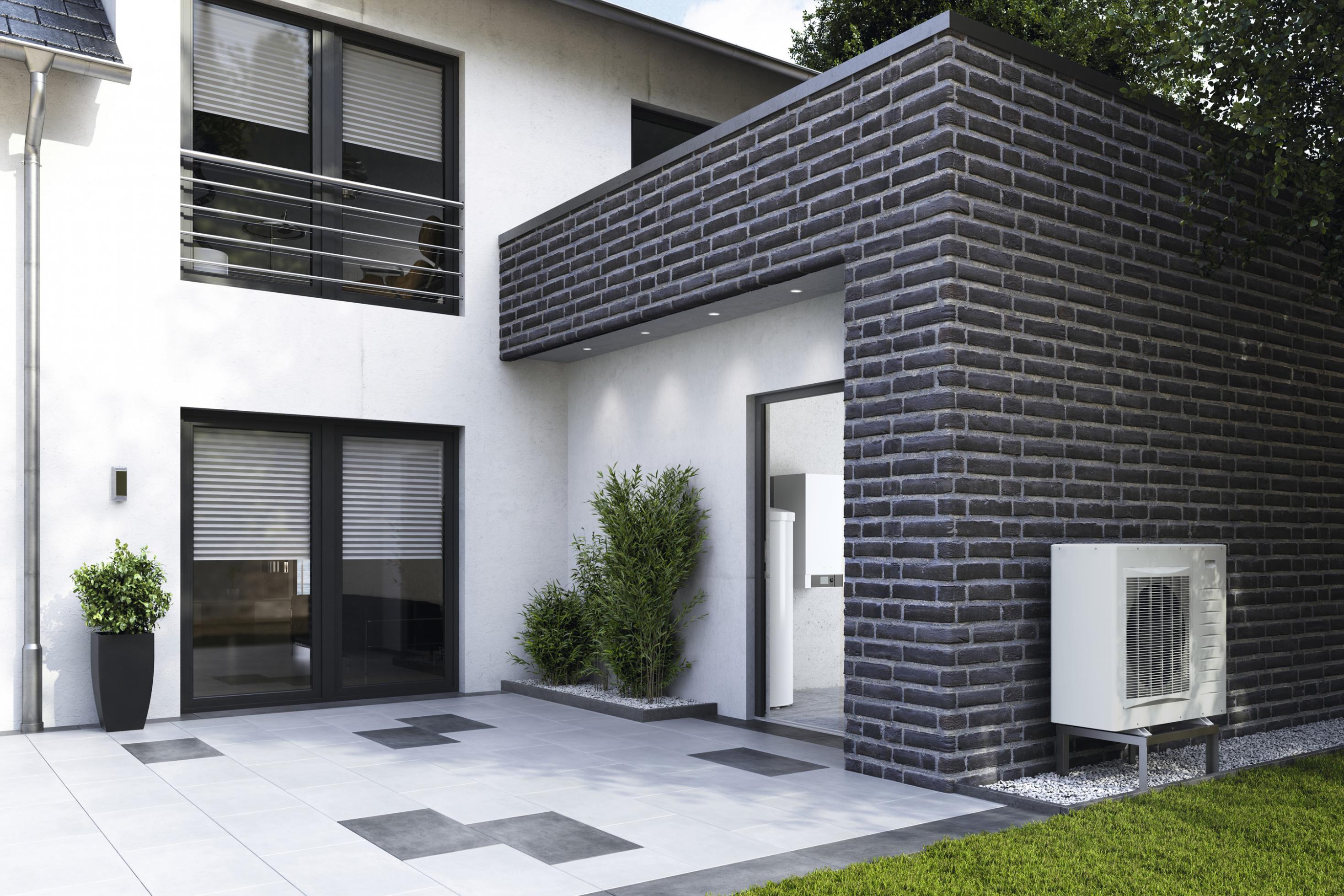 Außenansicht eines modernen Einfamilienhauses mit Wärmepumpe