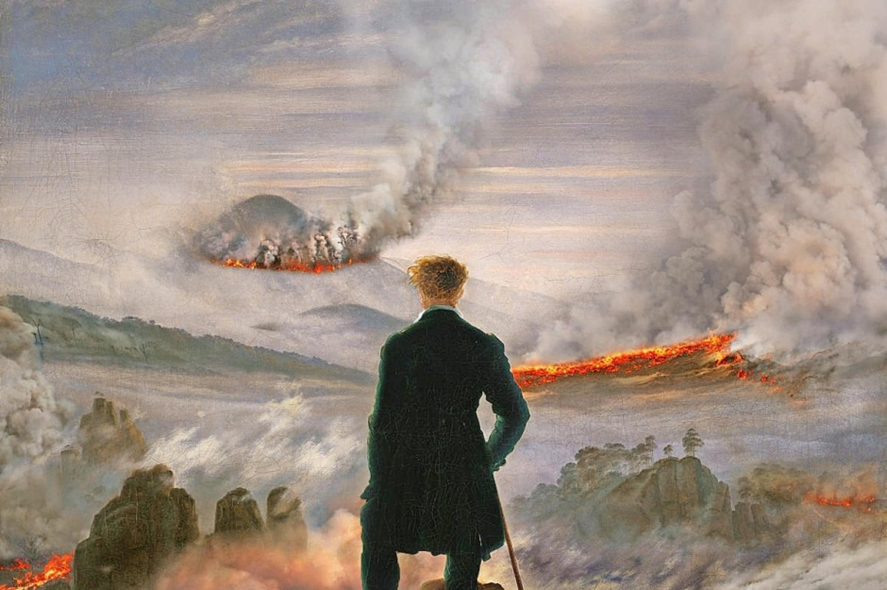 Das Bild zeigt einen Kunstdruck des Gemäldes „Der Wanderer im Nebelmeer“ von Caspar David Friedrich, auf dem im Hintergrund brennende Berghänge zu sehen sind.