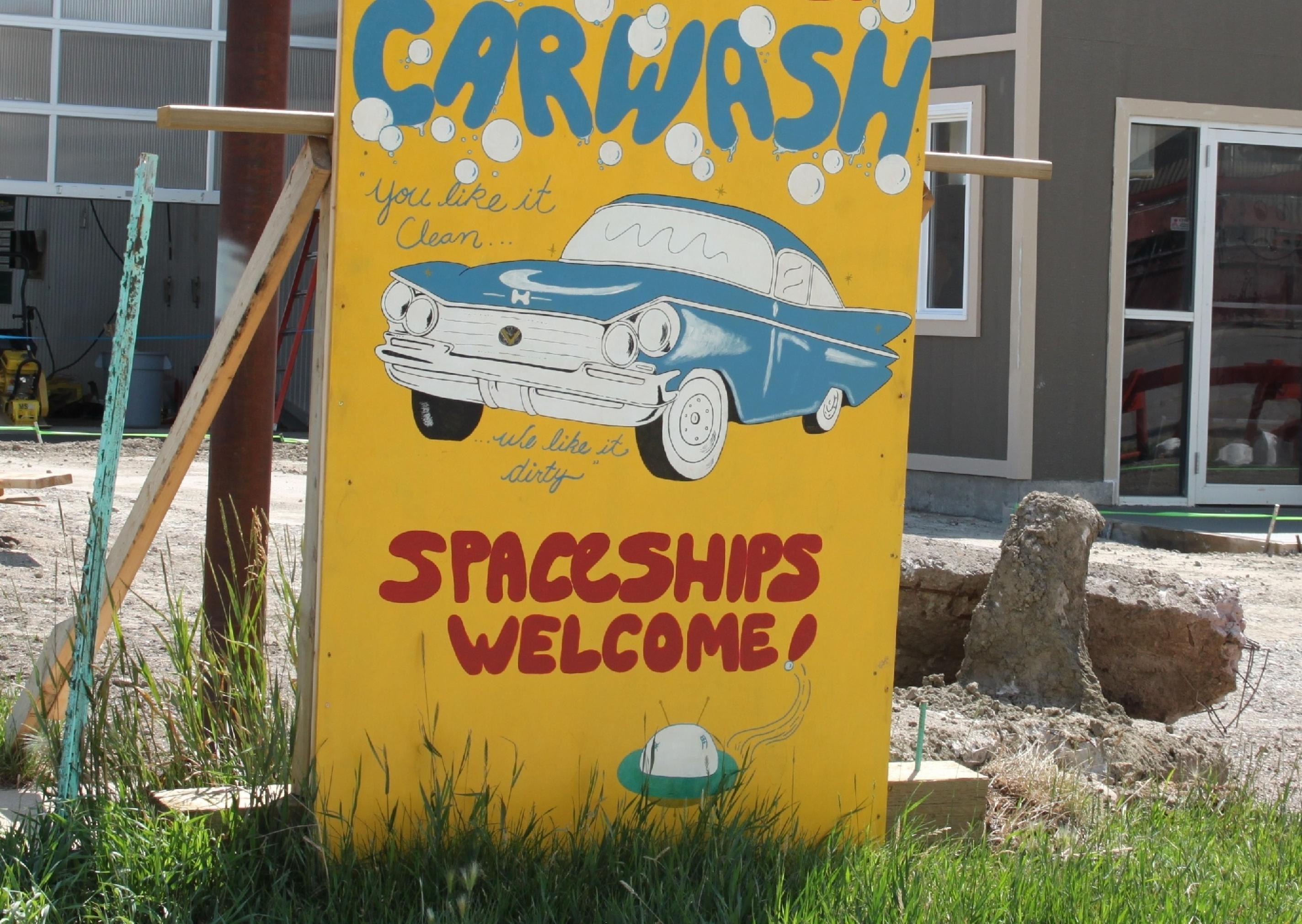 Ein Schild zeigt einen Oldtimer mit Seifenblasen. Aufschrift: „Spaceships Welcome“.
