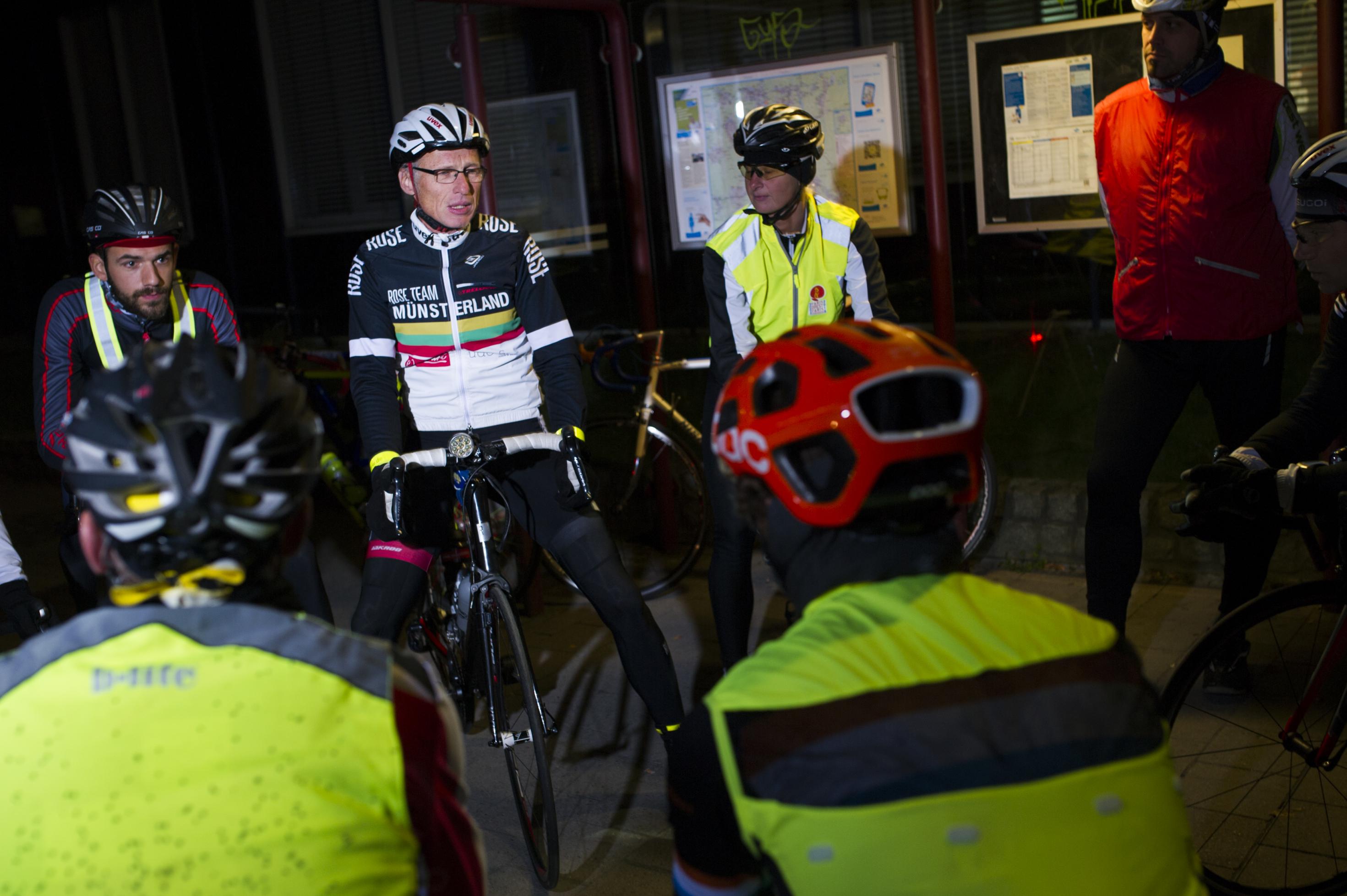 Gruppe von Rennradfahrern in der Nacht, stehend.