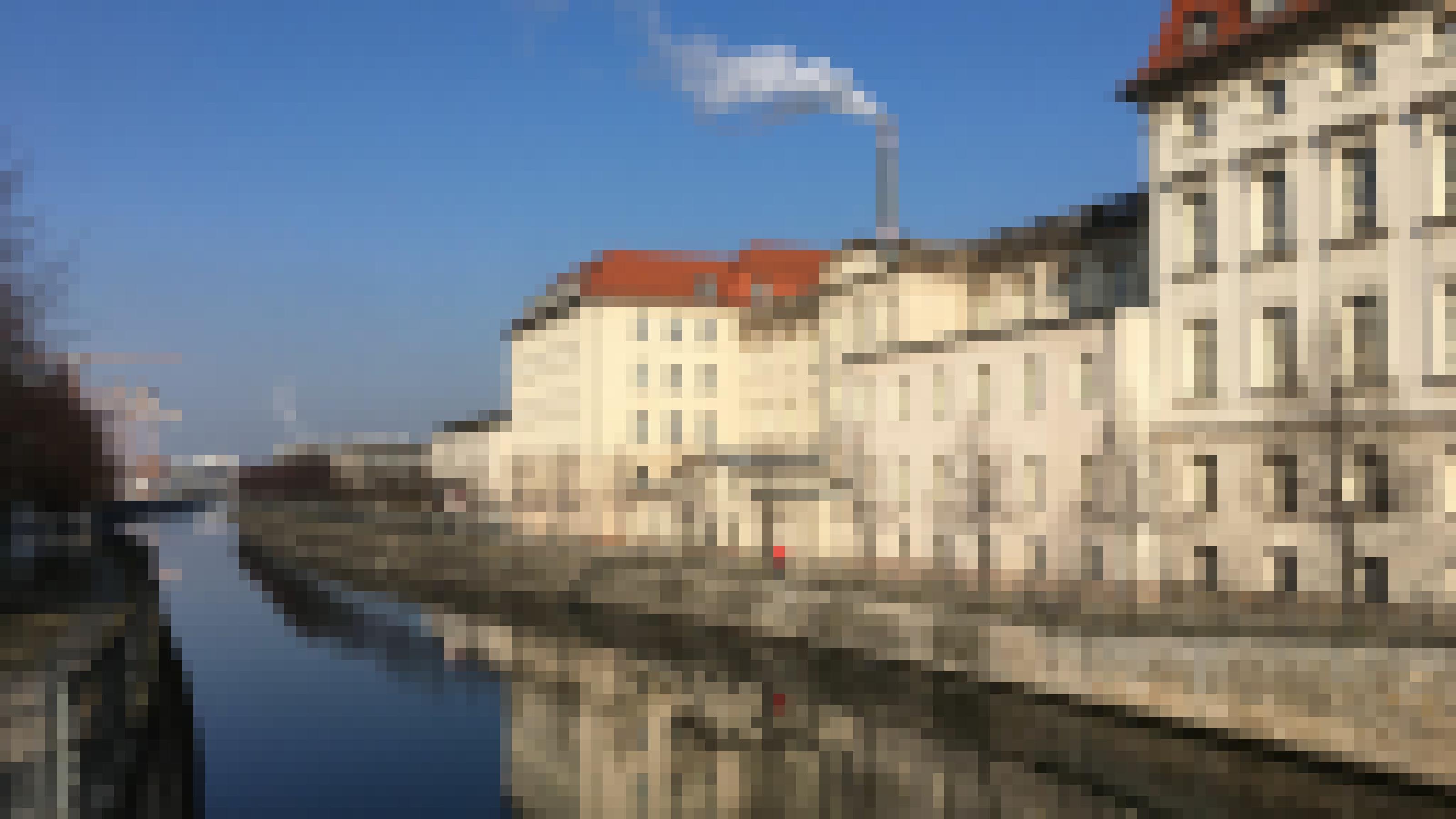 Das Foto zeigt die Rückfassade des Wirtschaftsministeriums von der Berliner Invalidenstraße aus. Die weiße Fassade spiegelt sich im Wasser, auf dem Mauerweg vor dem Gebäude geht ein Spaziergänger entlang.