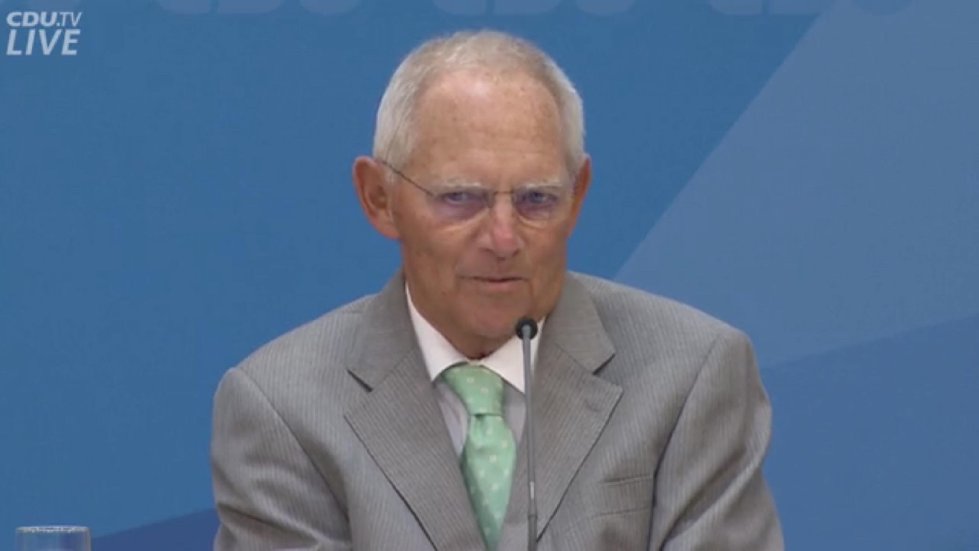 Wolfgang Schäuble, Bundestags-Präsident und CDU-Mitglied bei einer Rede. Er trägt einen grauen Anzug und sitzt vor einem blauen Hintergrund. –
„Lieber ein nicht perfekter Schritt in die konkrete Richtung, als auf der Suche nach der perfekten Lösung am Ende gar nichts zu machen.“  Wolfgang Schäuble redete seiner Partei bei deren Werkstattgespräch Anfang September 2019 ins Gewissen. Sie solle endlich mal mit dem Klimaschutz anfangen, meinte er und fügte mit sichtlicher Freude – die eigenen Fremdsprachenkenntnisse karikierend – hinzu: „Second bescht ist allemal besser als nossing.“