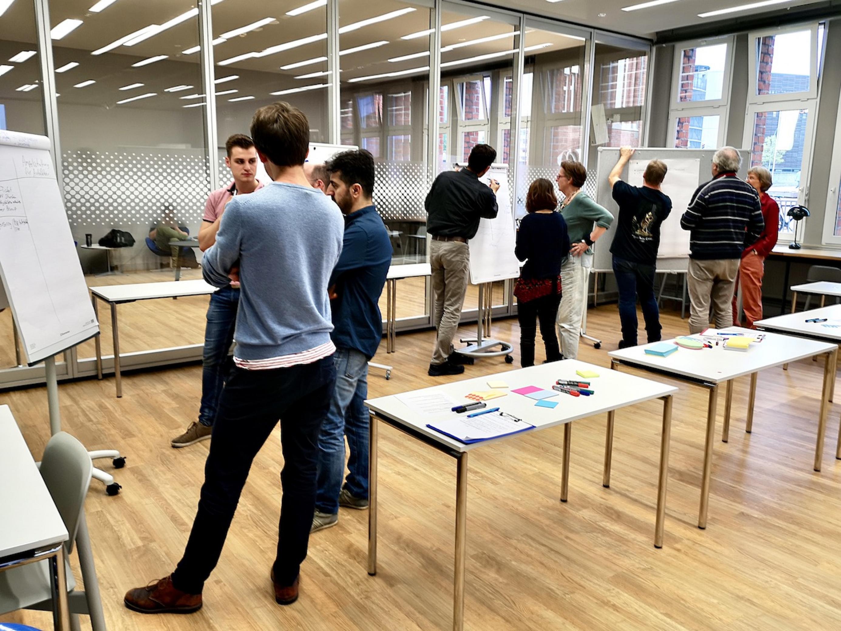Arbeitsphase in der Hamburger Zentralbibliothek: Vier Gruppen stehen vor den Stellwänden und diskutieren