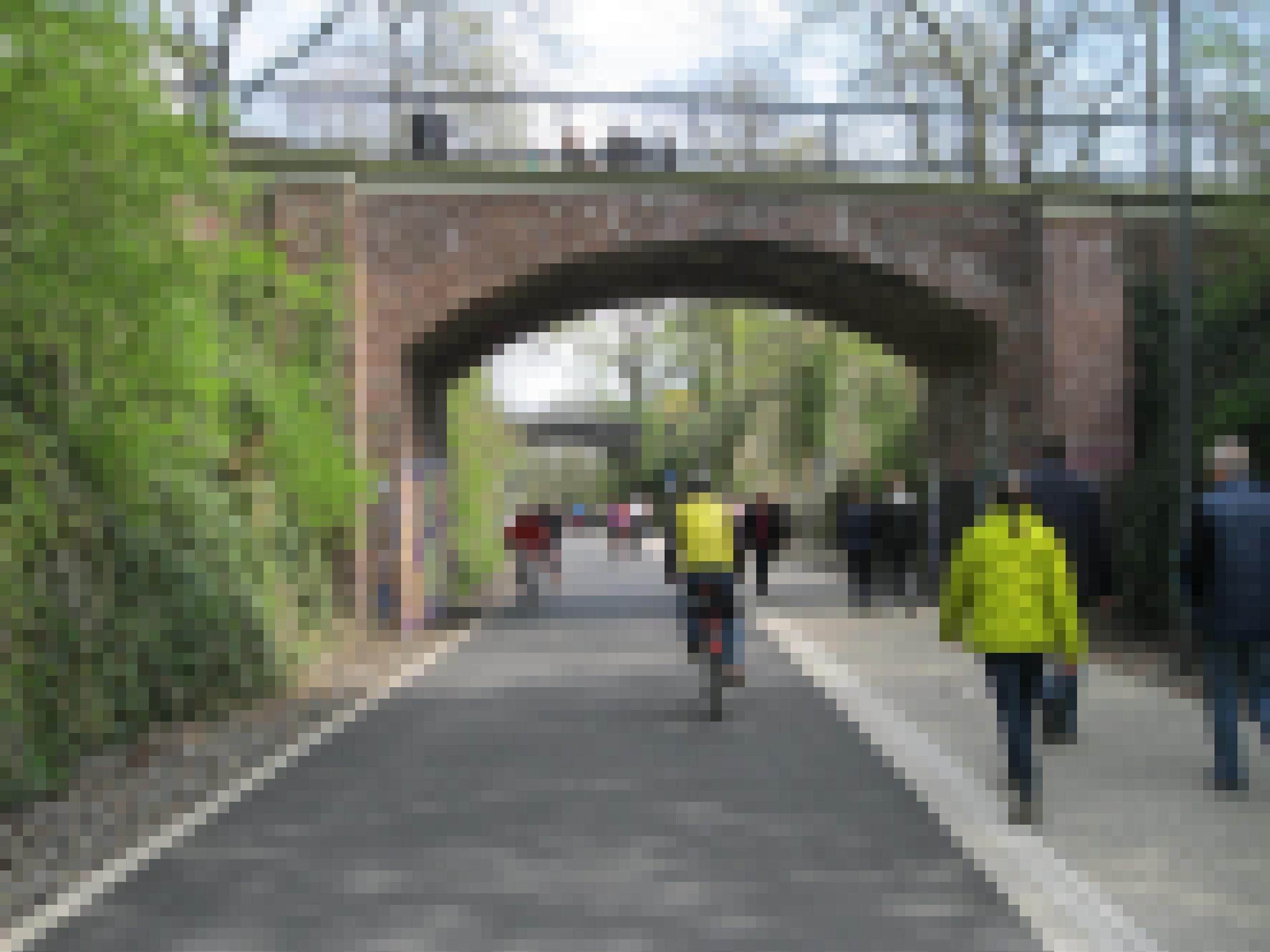 Unter einer Fußgängerbrücke herrscht reger Verkehr: Viele Fußgänger und Radfahrer sind hier unterwegs.